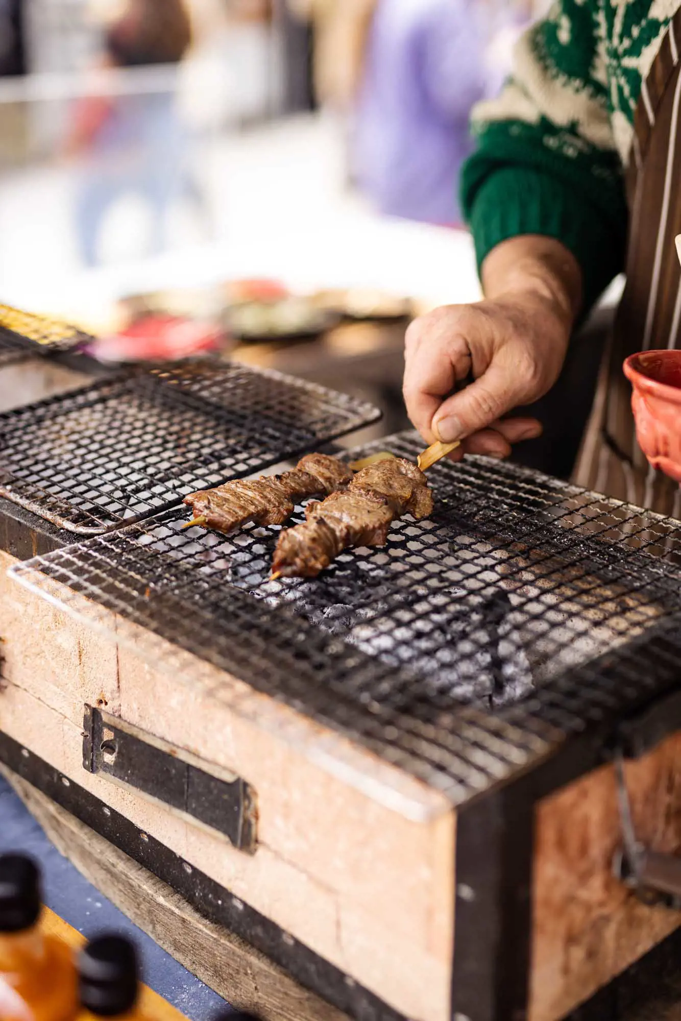 Beef on a bamboo skewer is cooked over the coals in a Japanese-style hibachi BBQ.