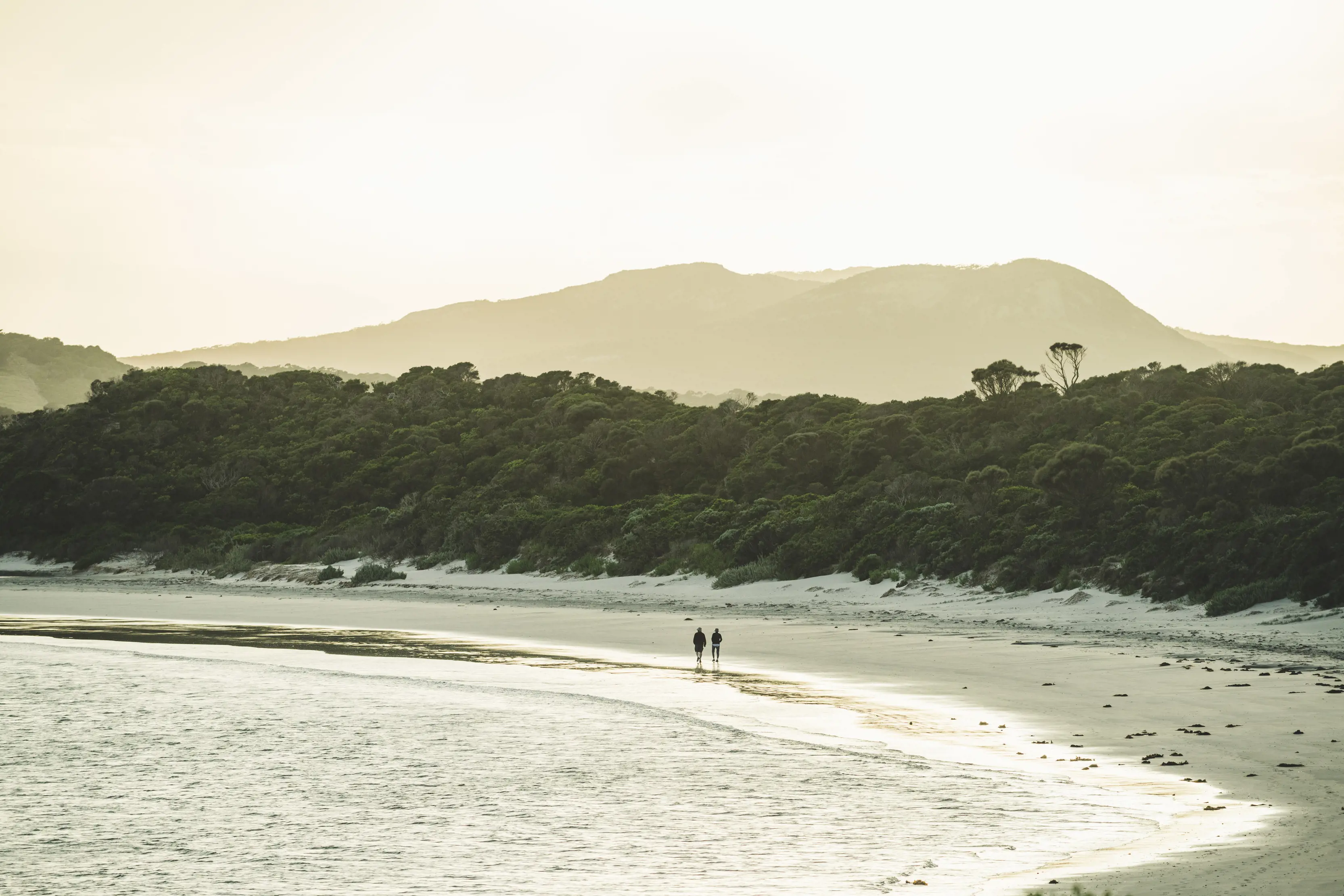 Stunning sunset with two people walking along Killiecrankie Bay, Flinders Island.
