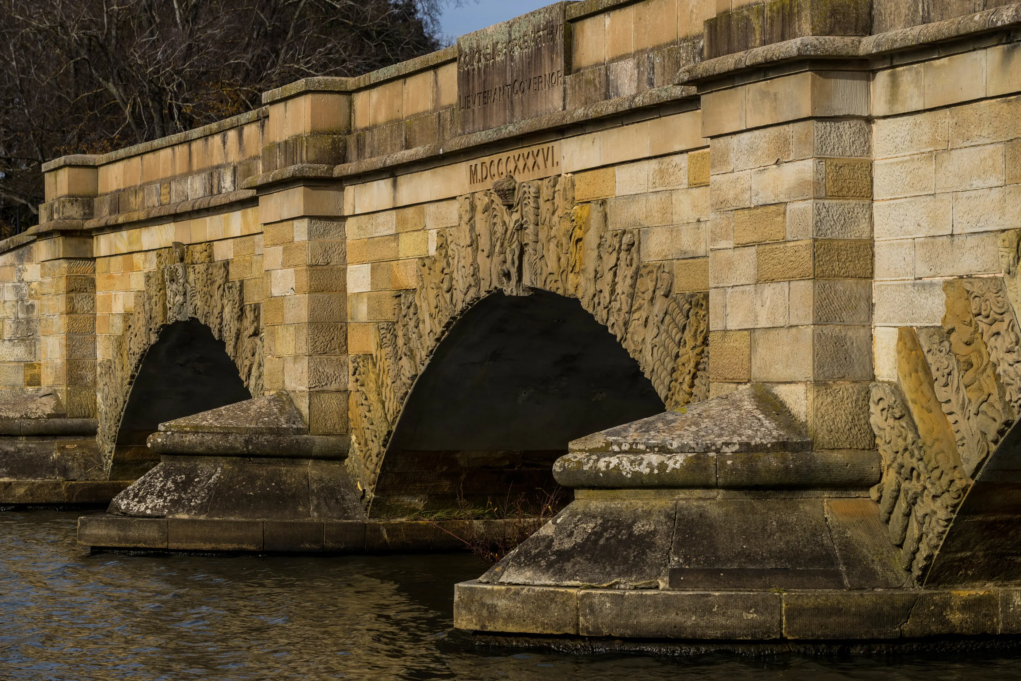 Close up image of the charming sandstone Ross Bridge and surrounding water. 