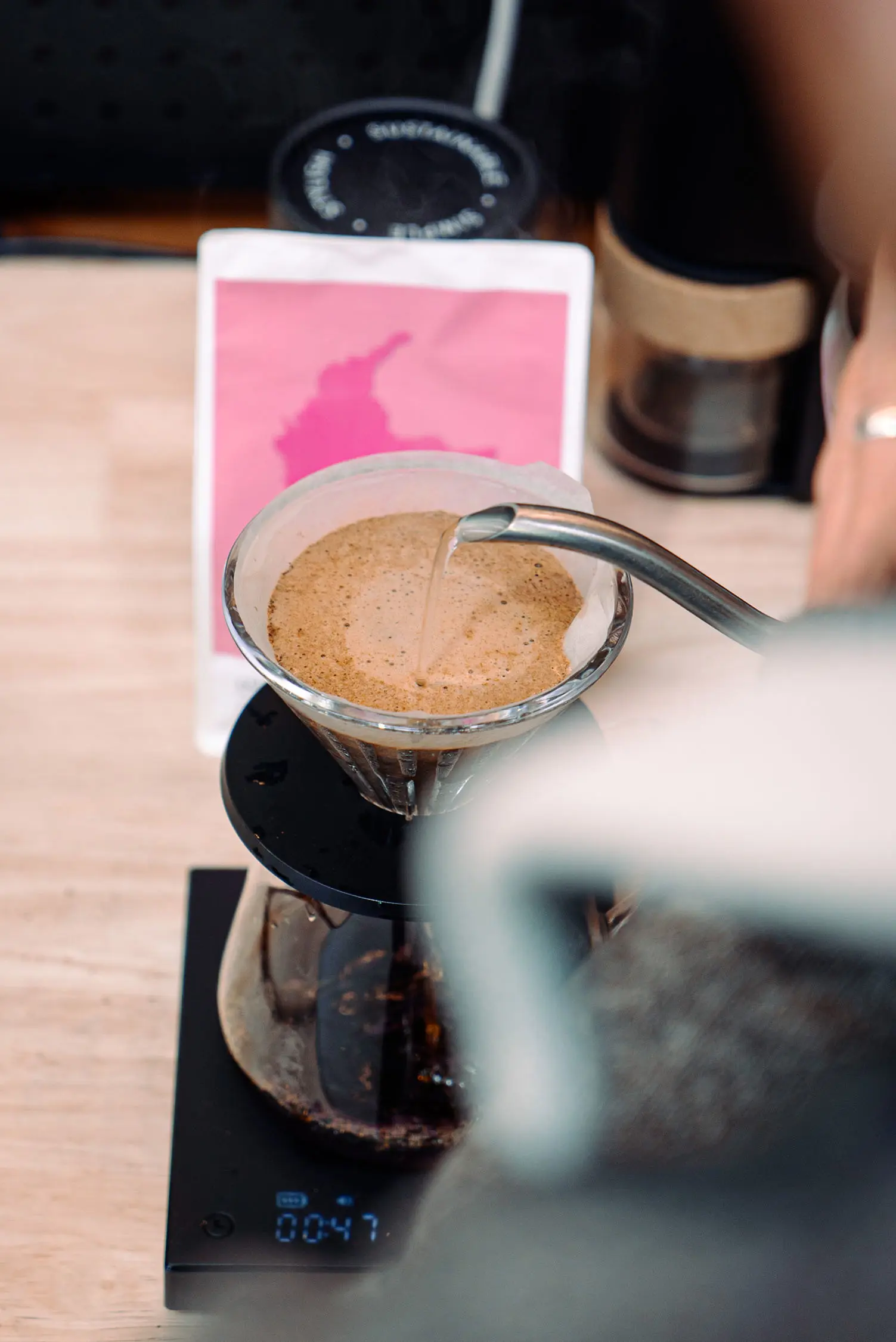 A close-up of a barista preparing a pour-over coffee.