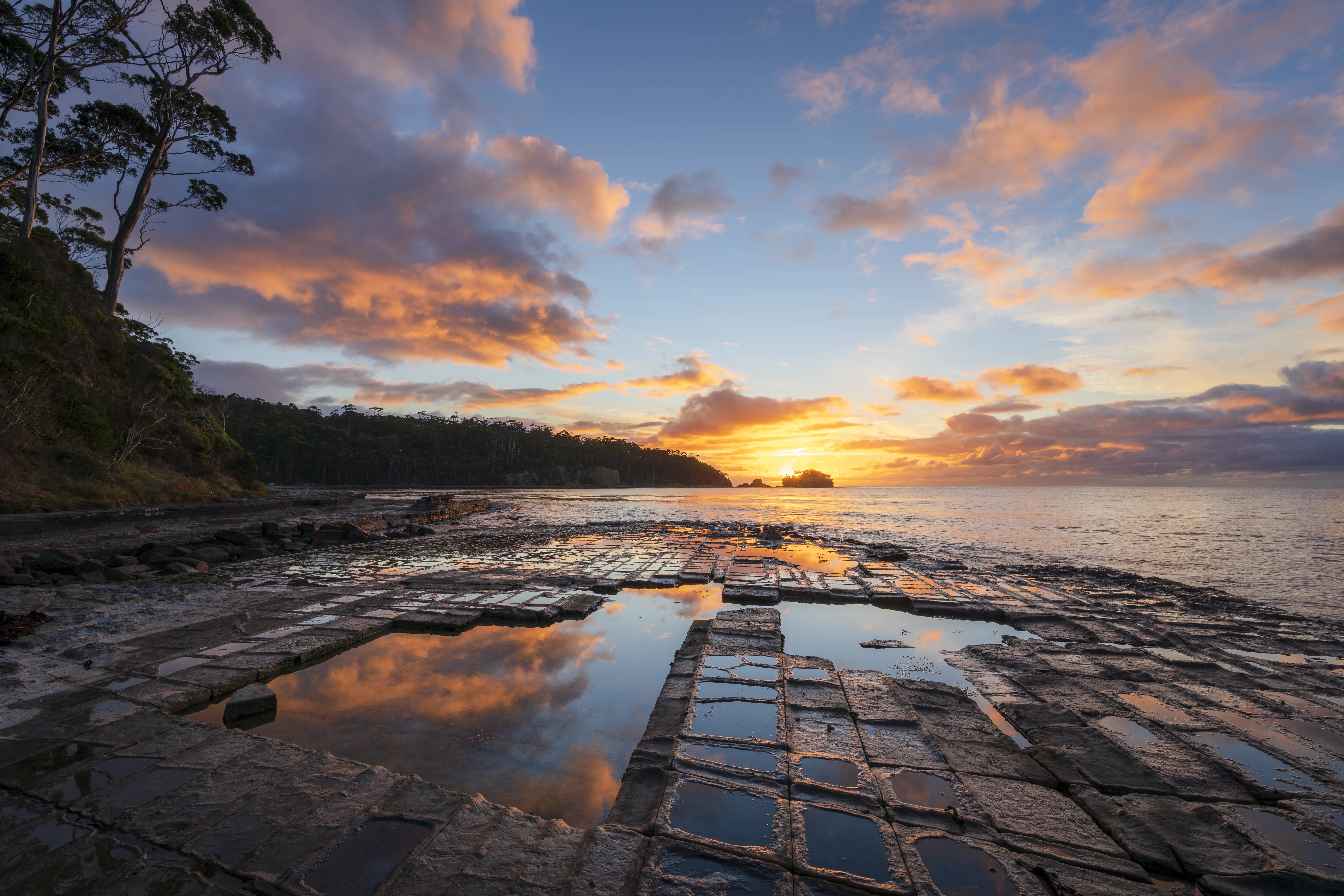 Tessellated pattern rock formation with a sunrise in the background