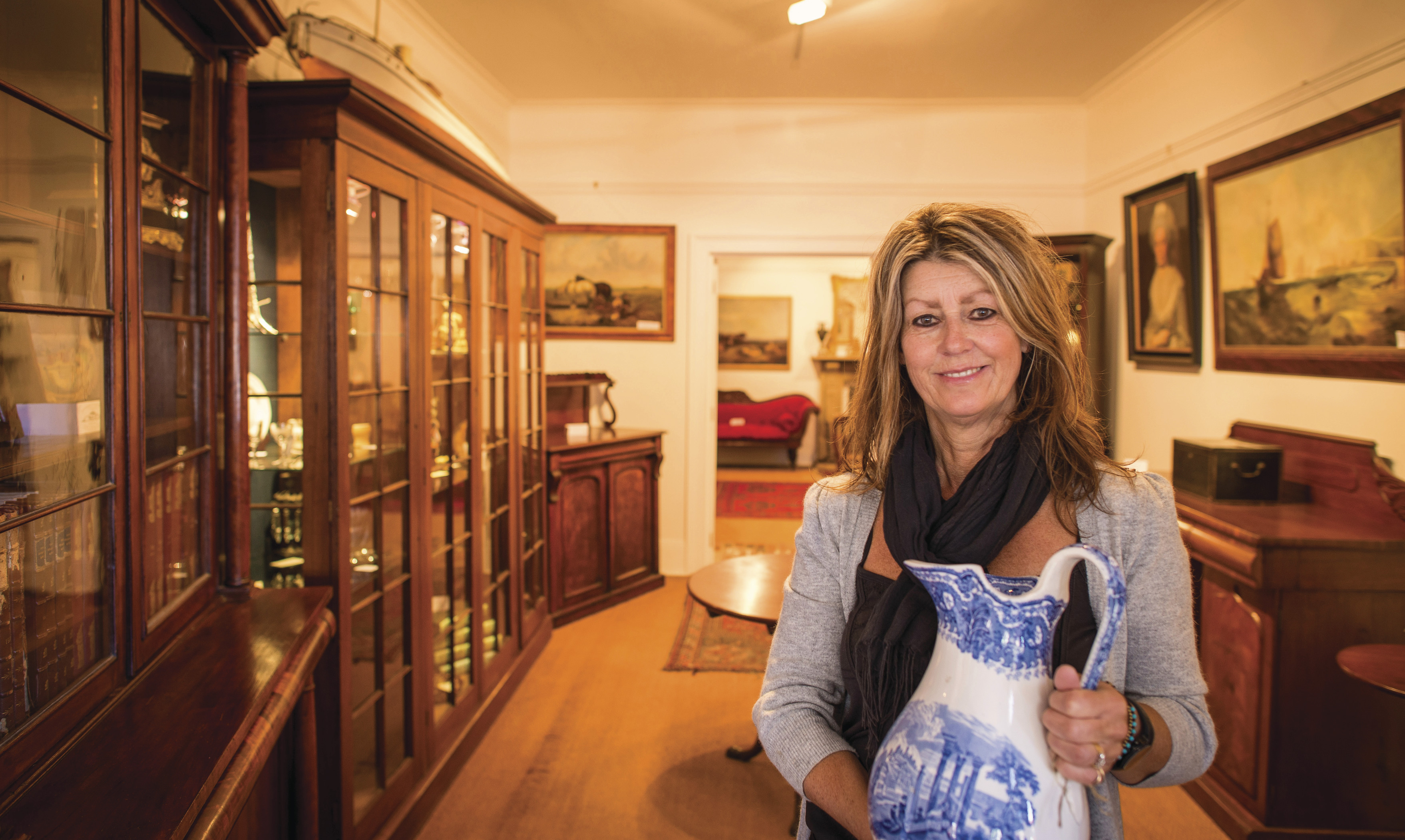 Woman holds a white and blue vase at Evandale Antiques