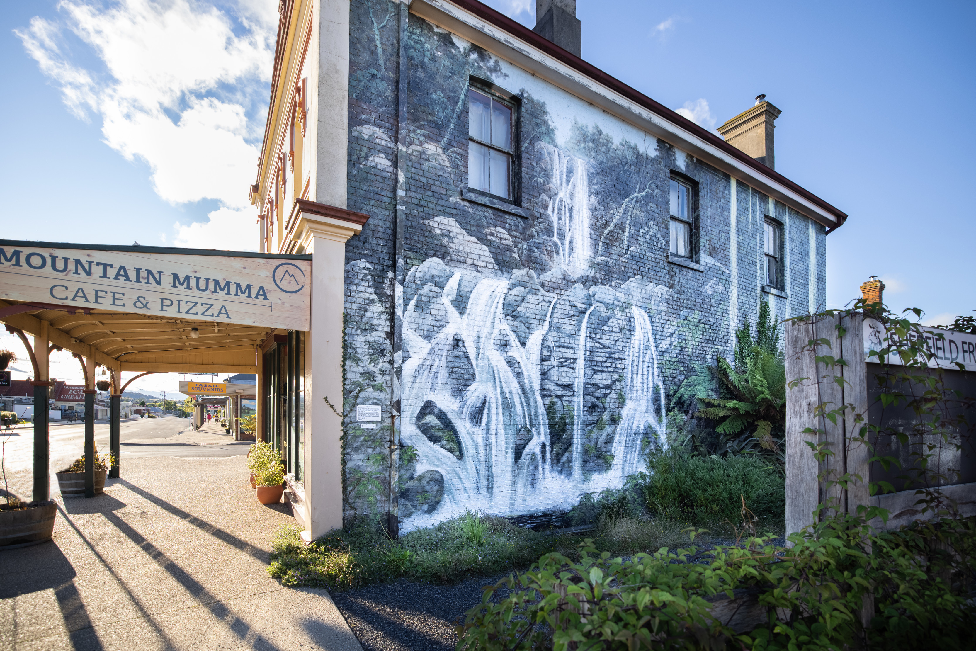 Stunning waterfall mural painted on the side of Mountain Mumma Cafe and Pizza.