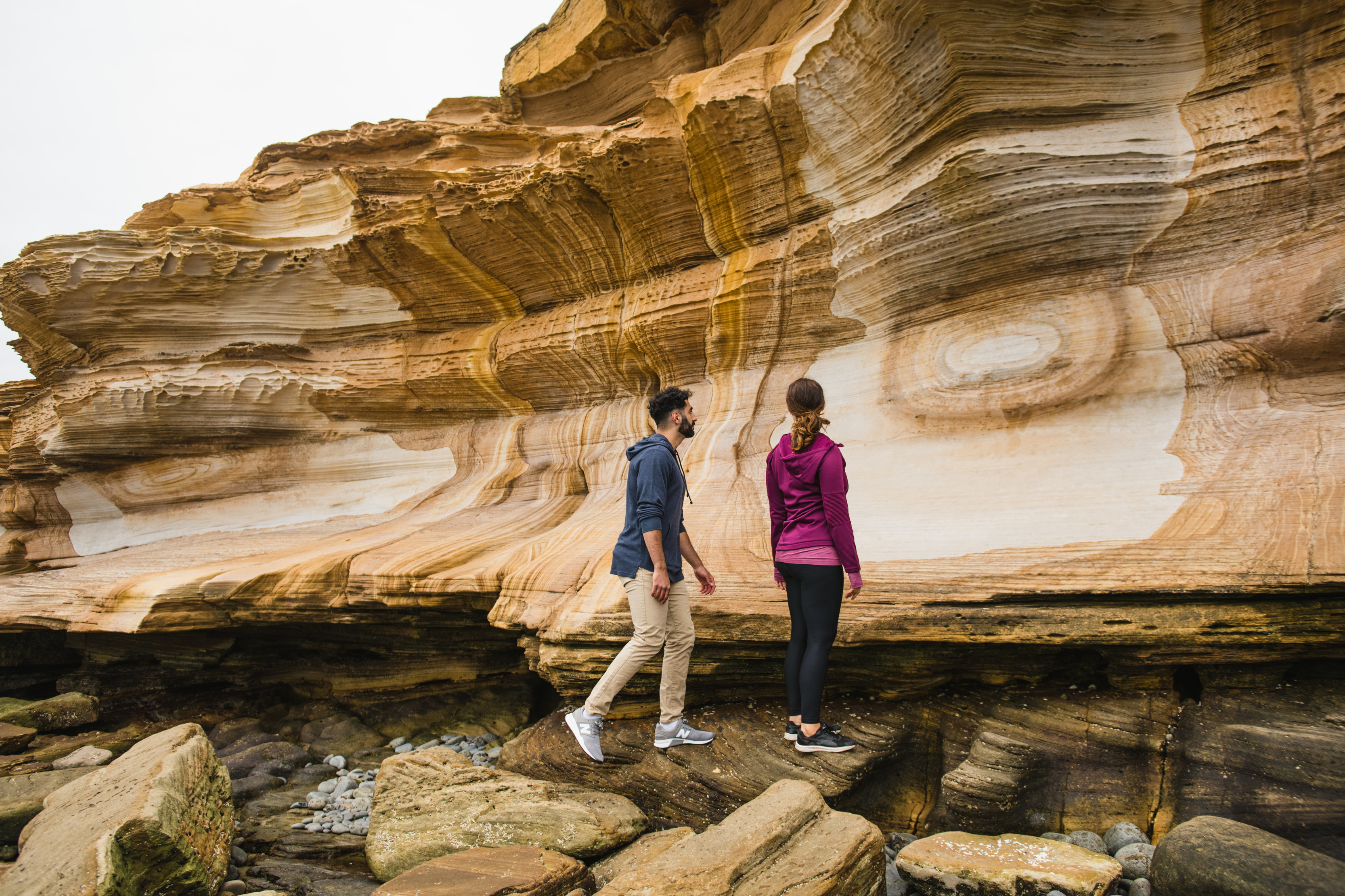 Couple exploring the unique patterns of the Painted cliffs.