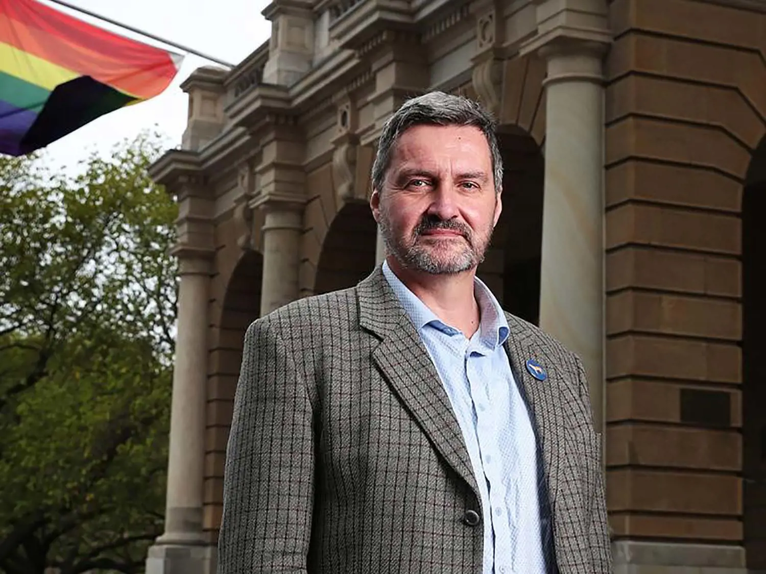 Rodney Croome standing in front of Hobart City Hall