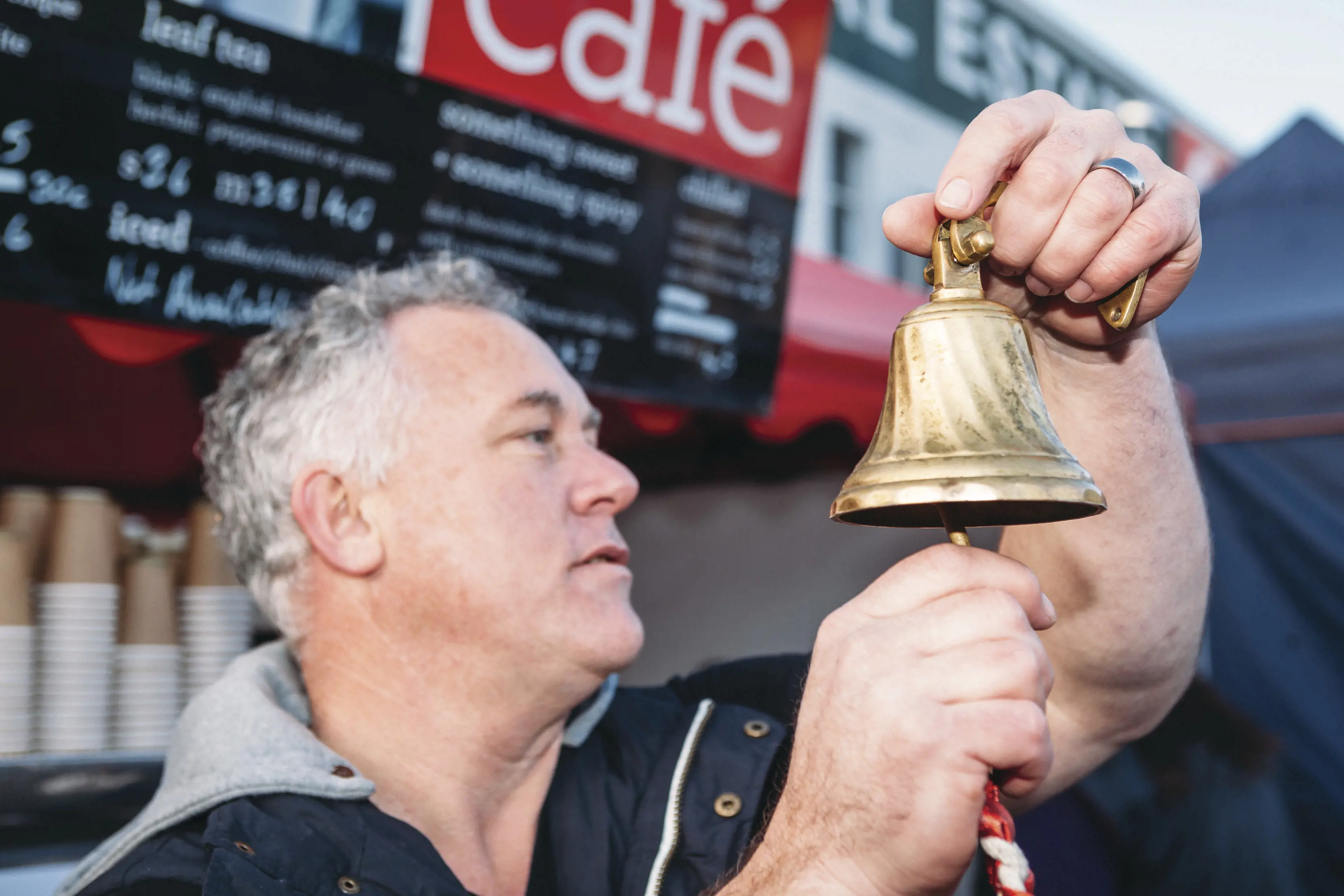 Man ringing a bell at Farm Gate Market, Hobart.