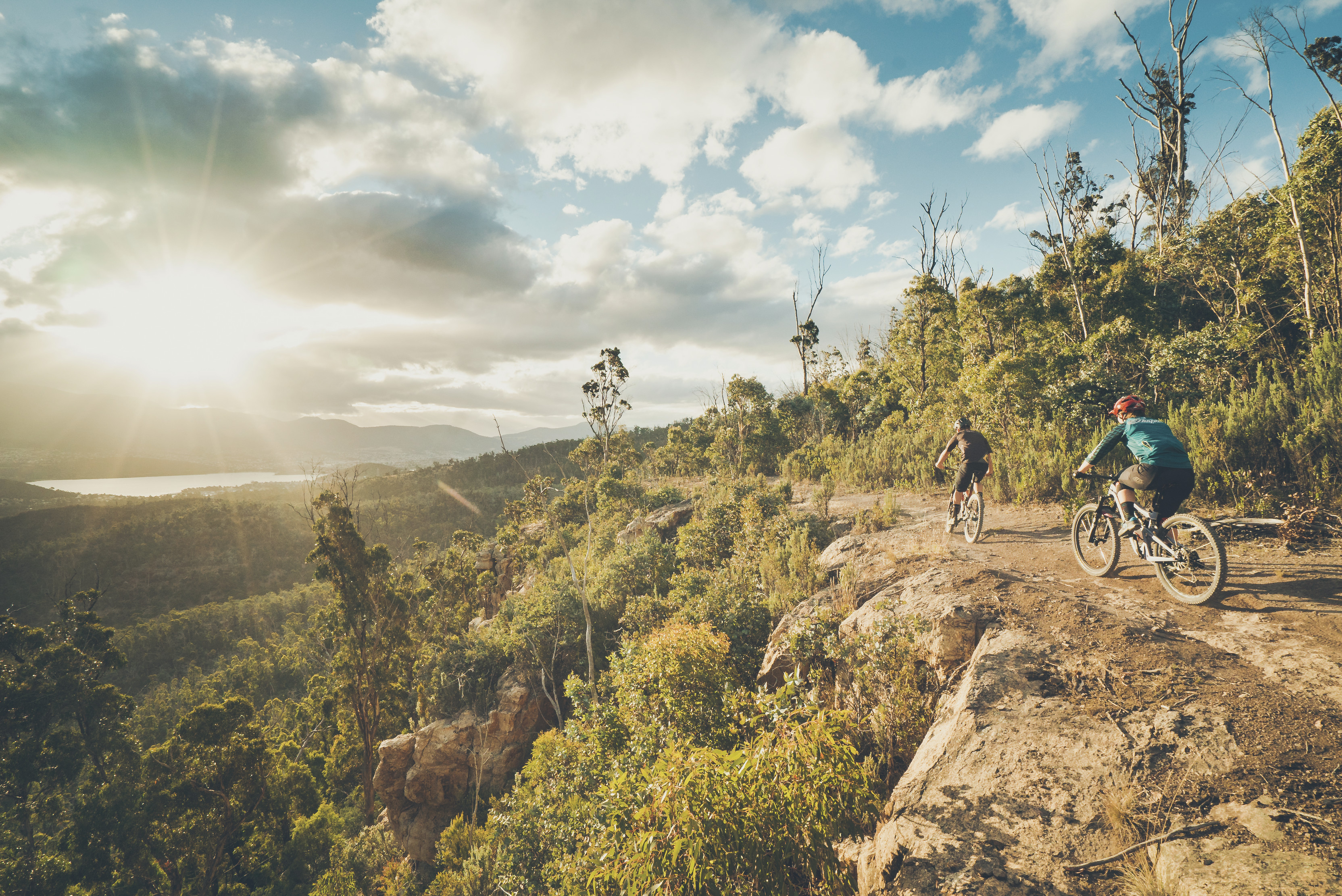 Cyclists on the The Clarence Mountain Bike Park clifftop track, located in the Meehan Range on Hobart’s eastern shore.