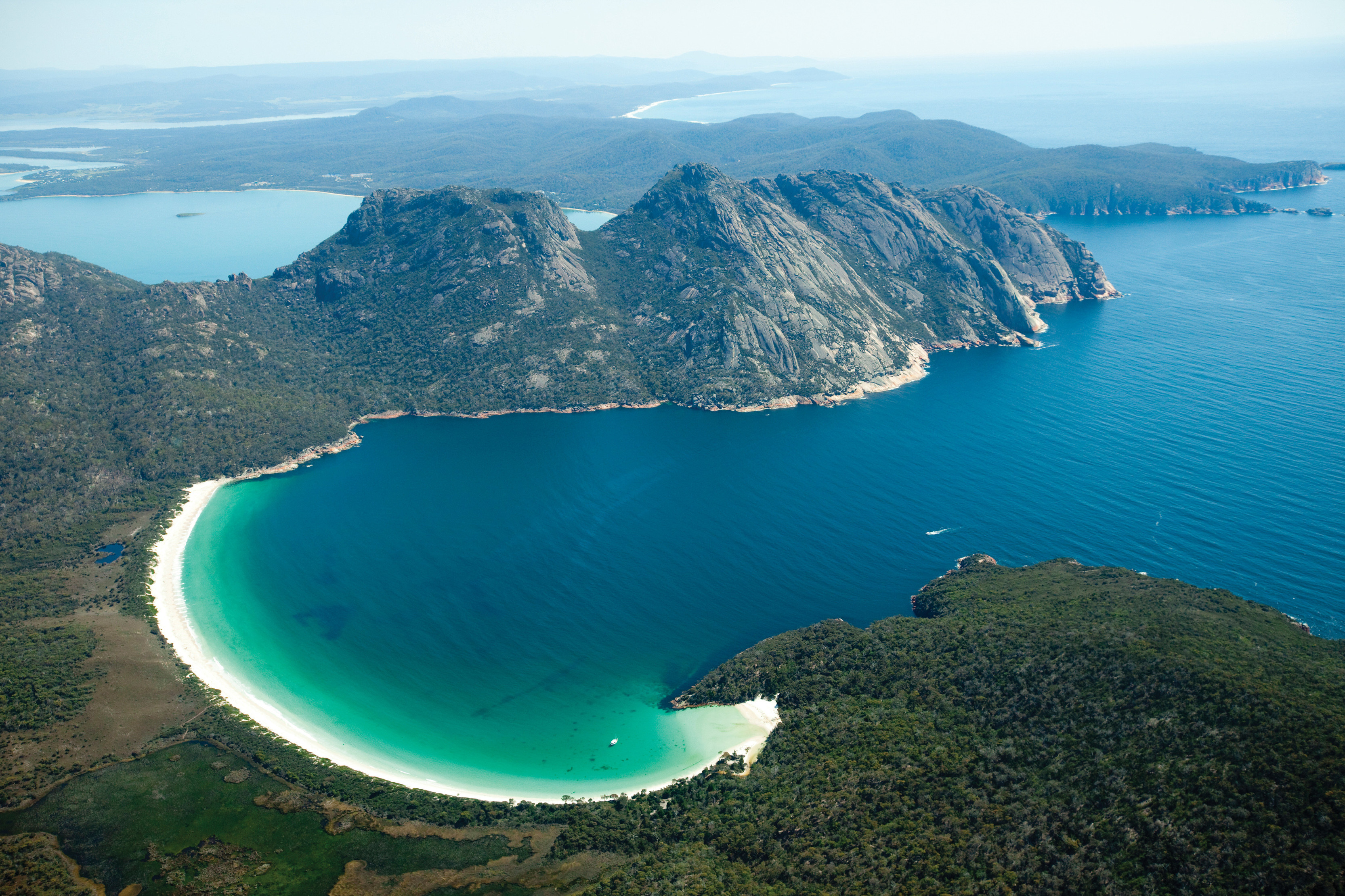 Aerial view of Wineglass Bay, Freycinet National Park, with Mount Mayson, Mount Amos and Mount Dove in the backdrop.