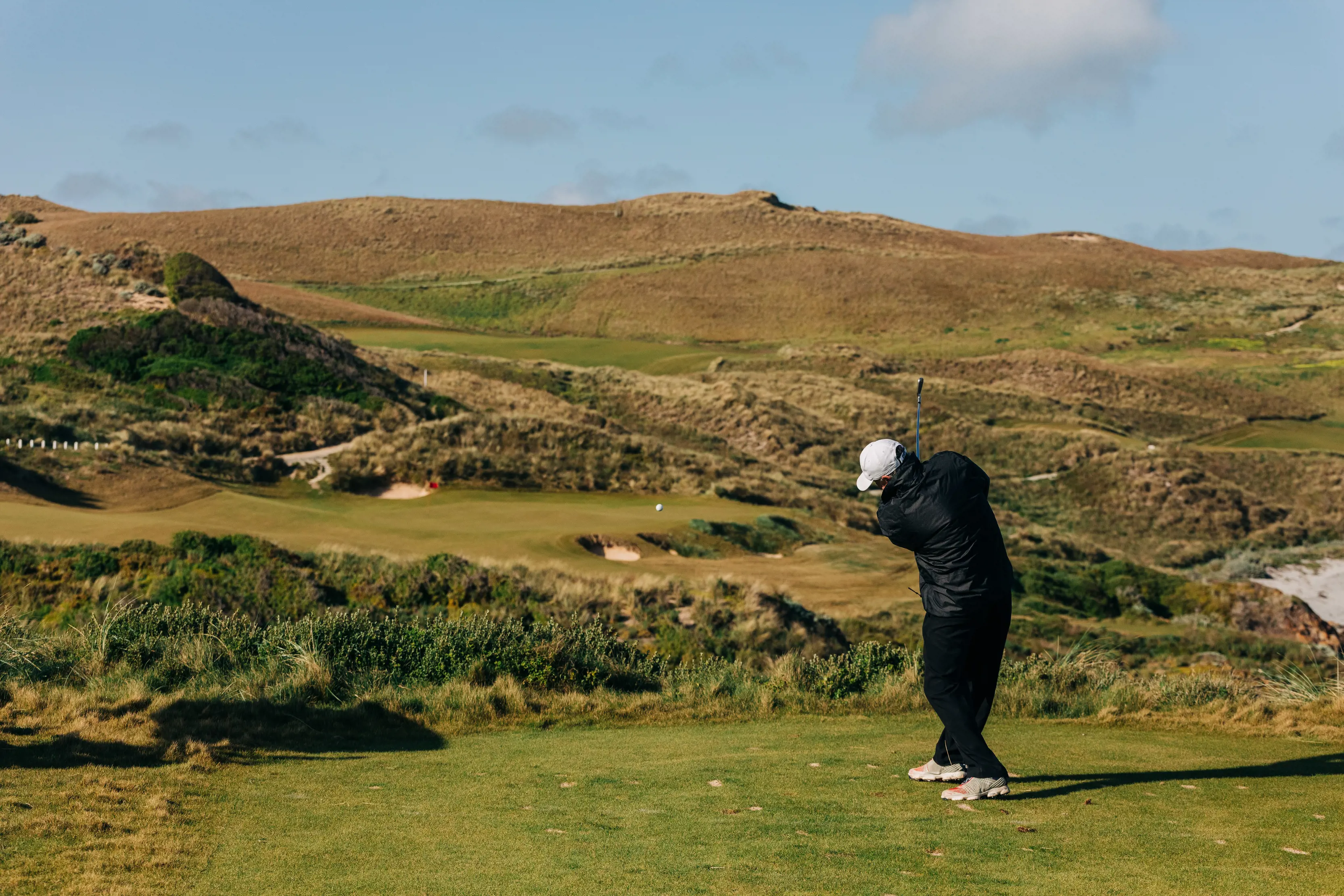 A golfer takes a sing amongst the green landscape at Cape Wickham Golf Course.