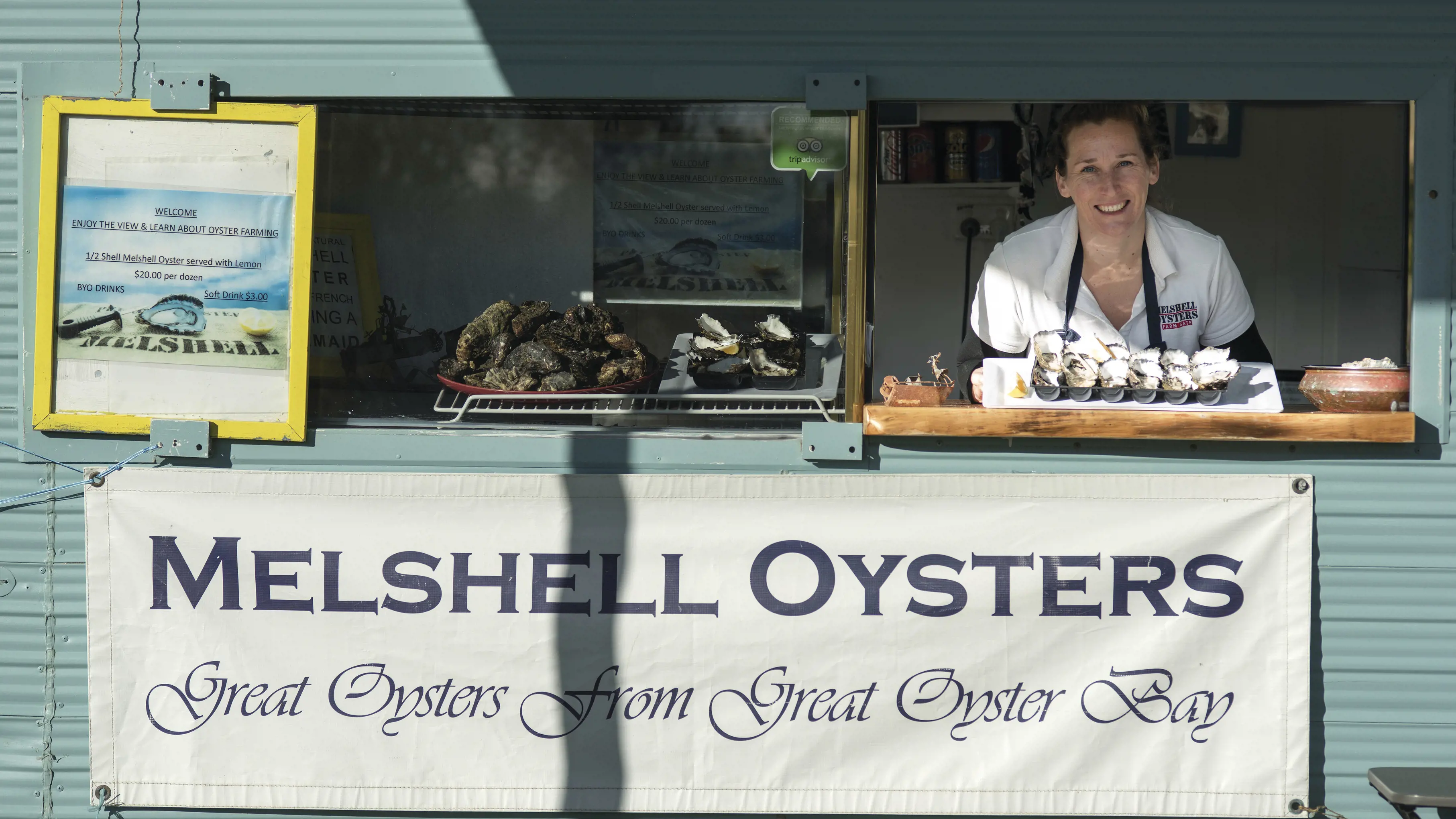 Image of Cassy Melrose in her shack, Melshell Oysters Farm Gate, holding a platter of oysters.
