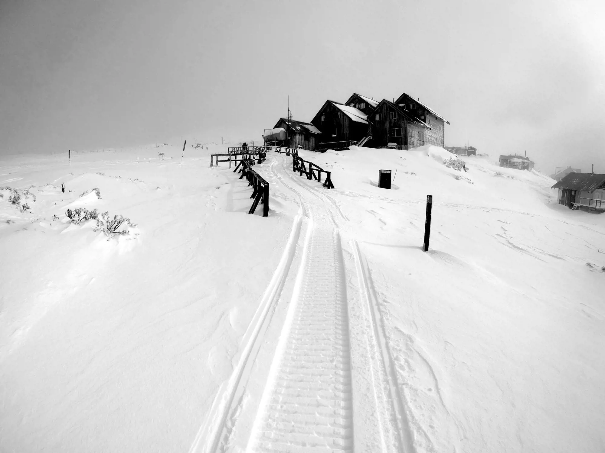 A wooden ski lodge stands at the top of a gentle snow-covered slope at Ben Lomond.