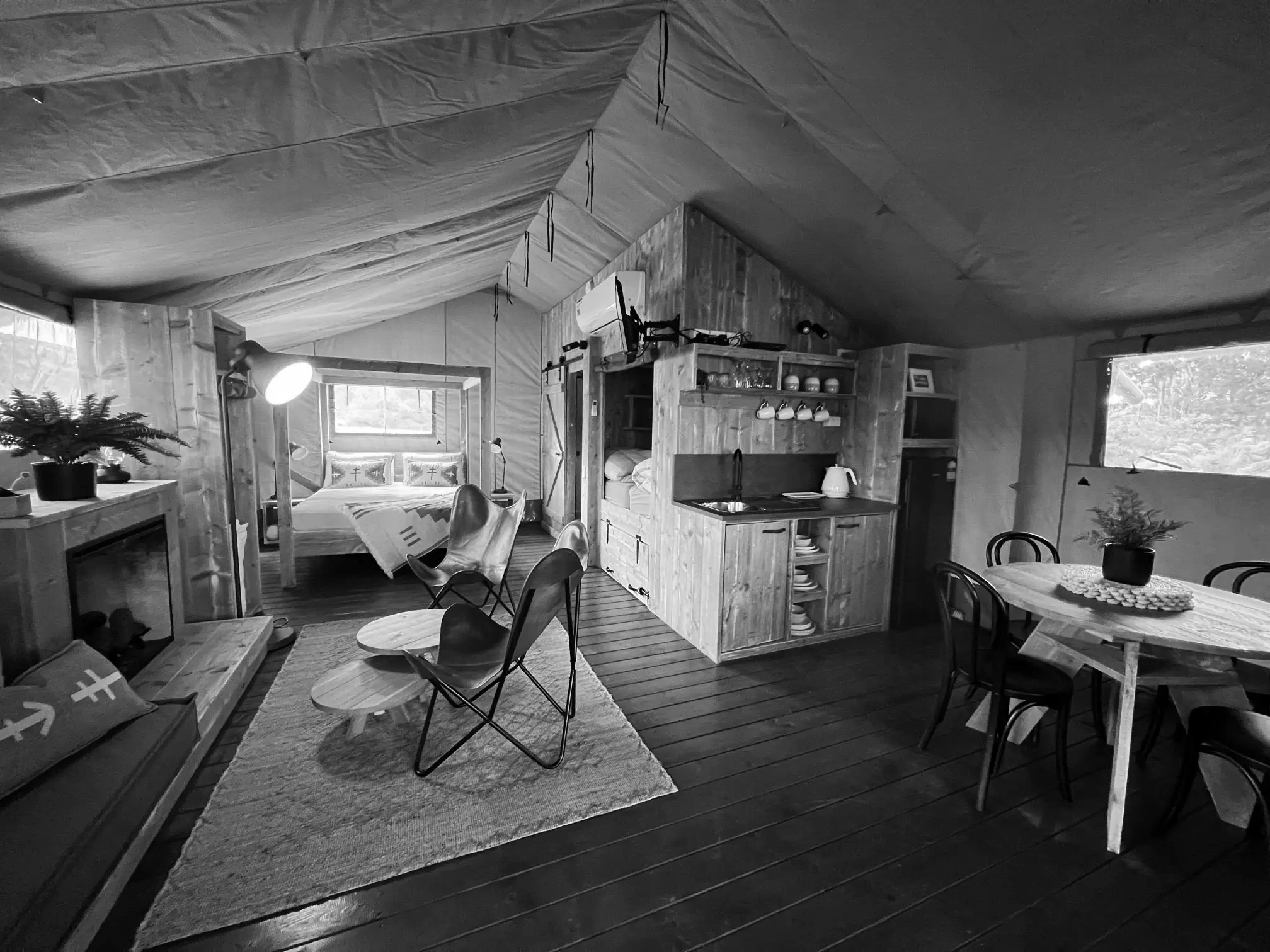 The interior of a safari-style glamping tent, fully decked out with cosy furniture and creature comforts.