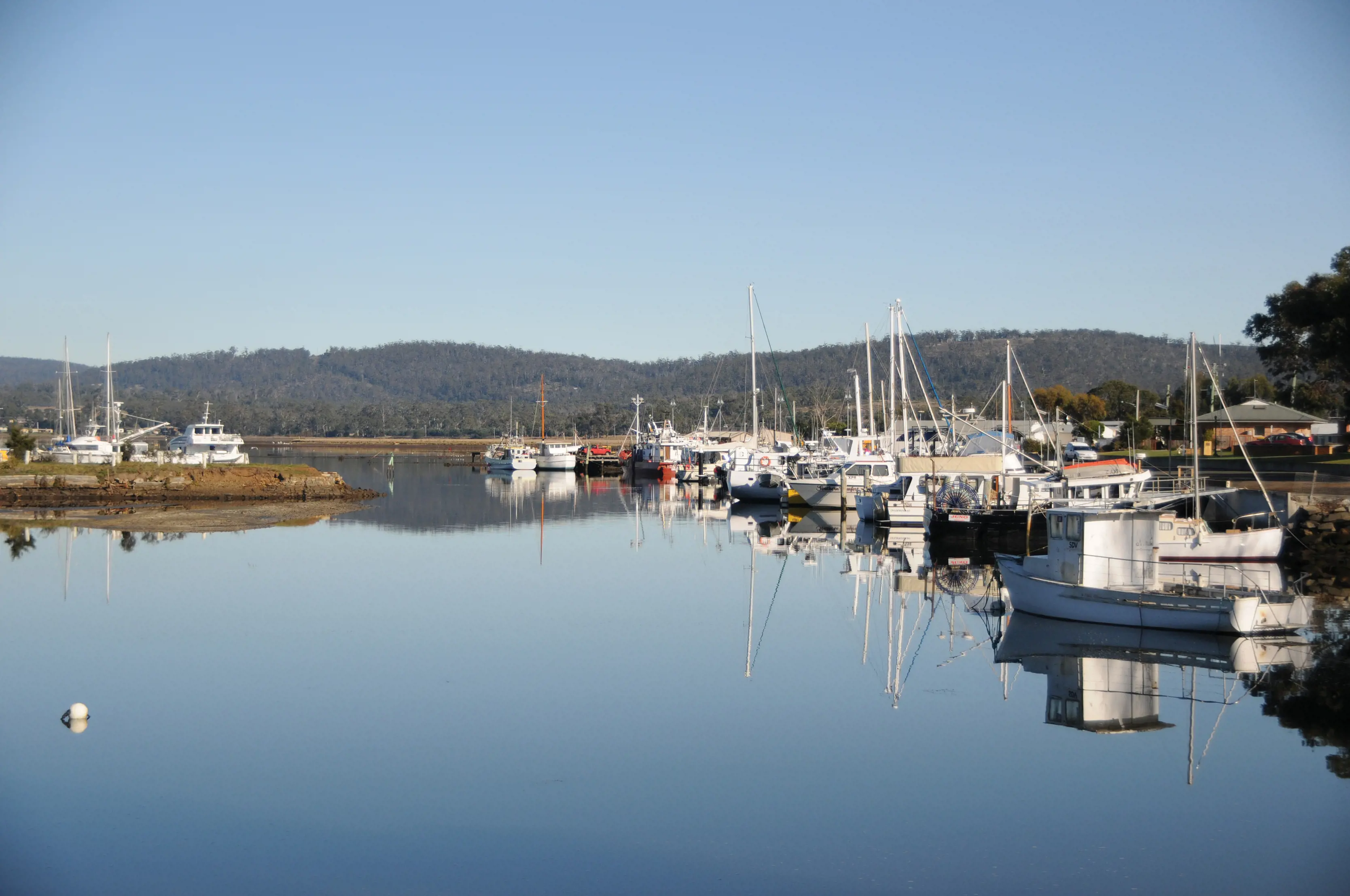 Landscape of boats parked up at Triabunna waterfront.