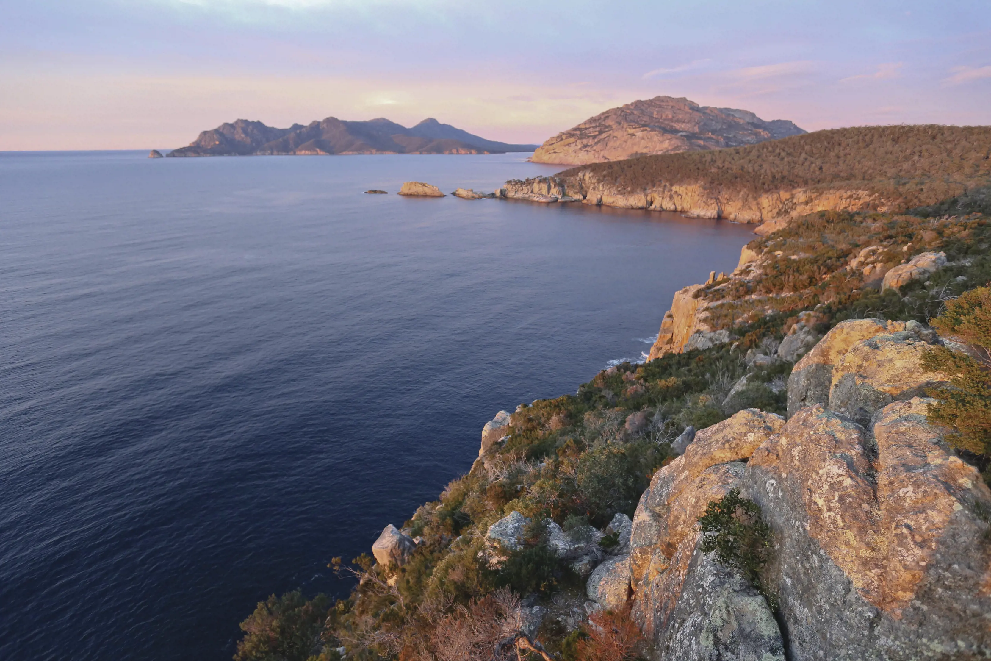 Birds eye view over Sleepy Bay, Freycinet Peninsula. Ocean view on the left, up against the mountain cliffs on the right. 