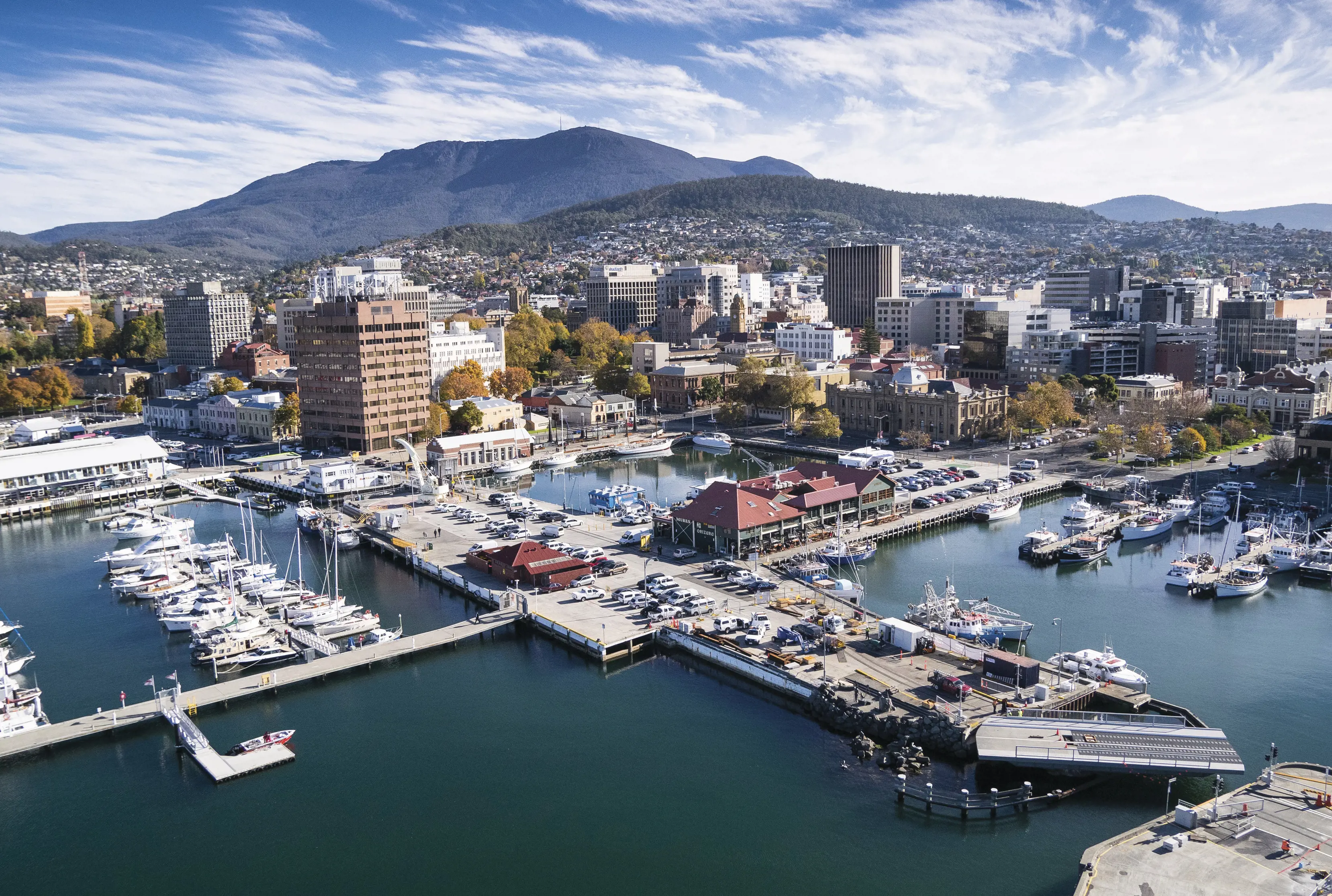 Aerial view of Hobart's marina with kunanyi/Mt Wellington towering in the background.