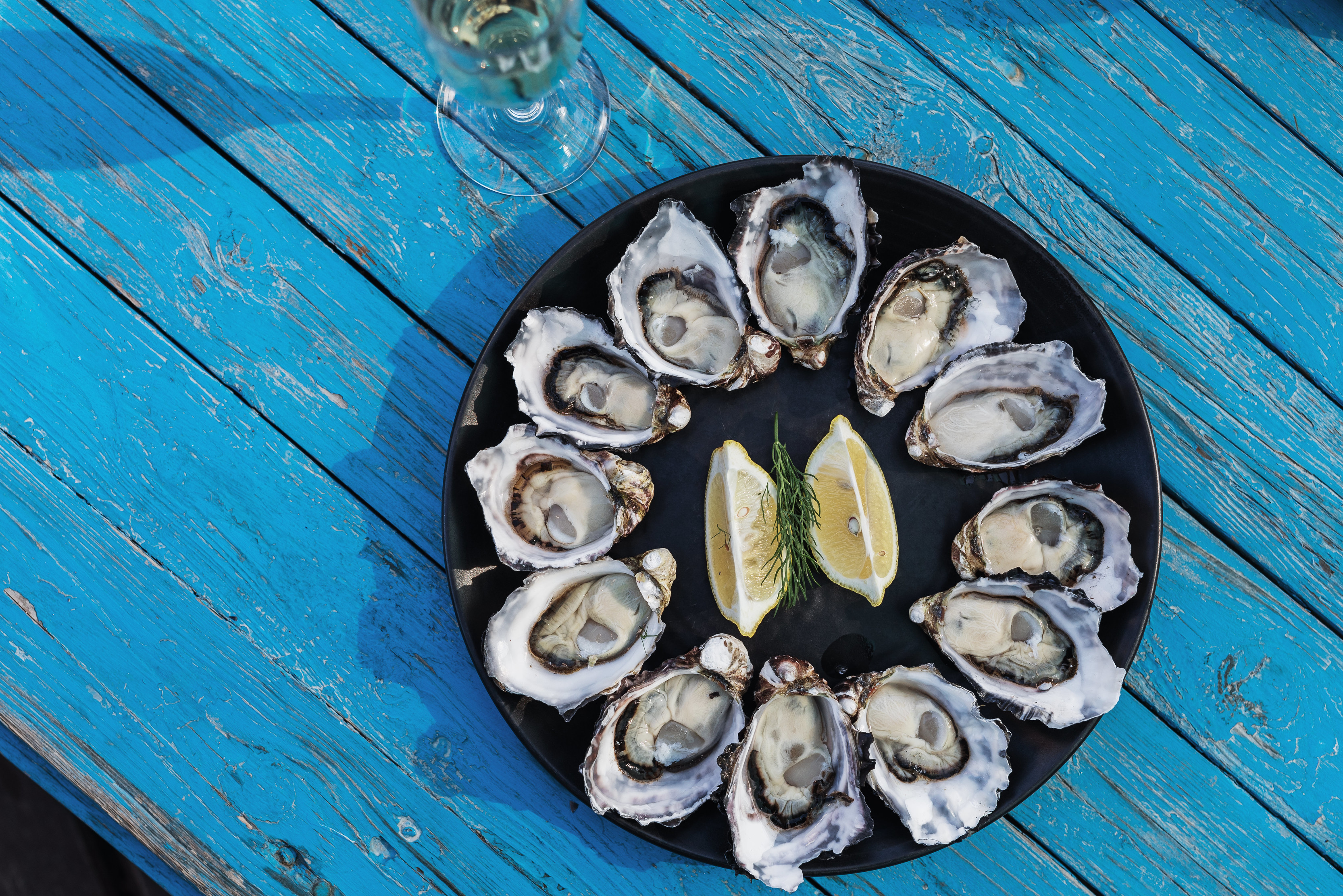 Delicious close up image of a platter of Bruny Island Oysters with lemon wedges in the middle, located at Get Shucked.