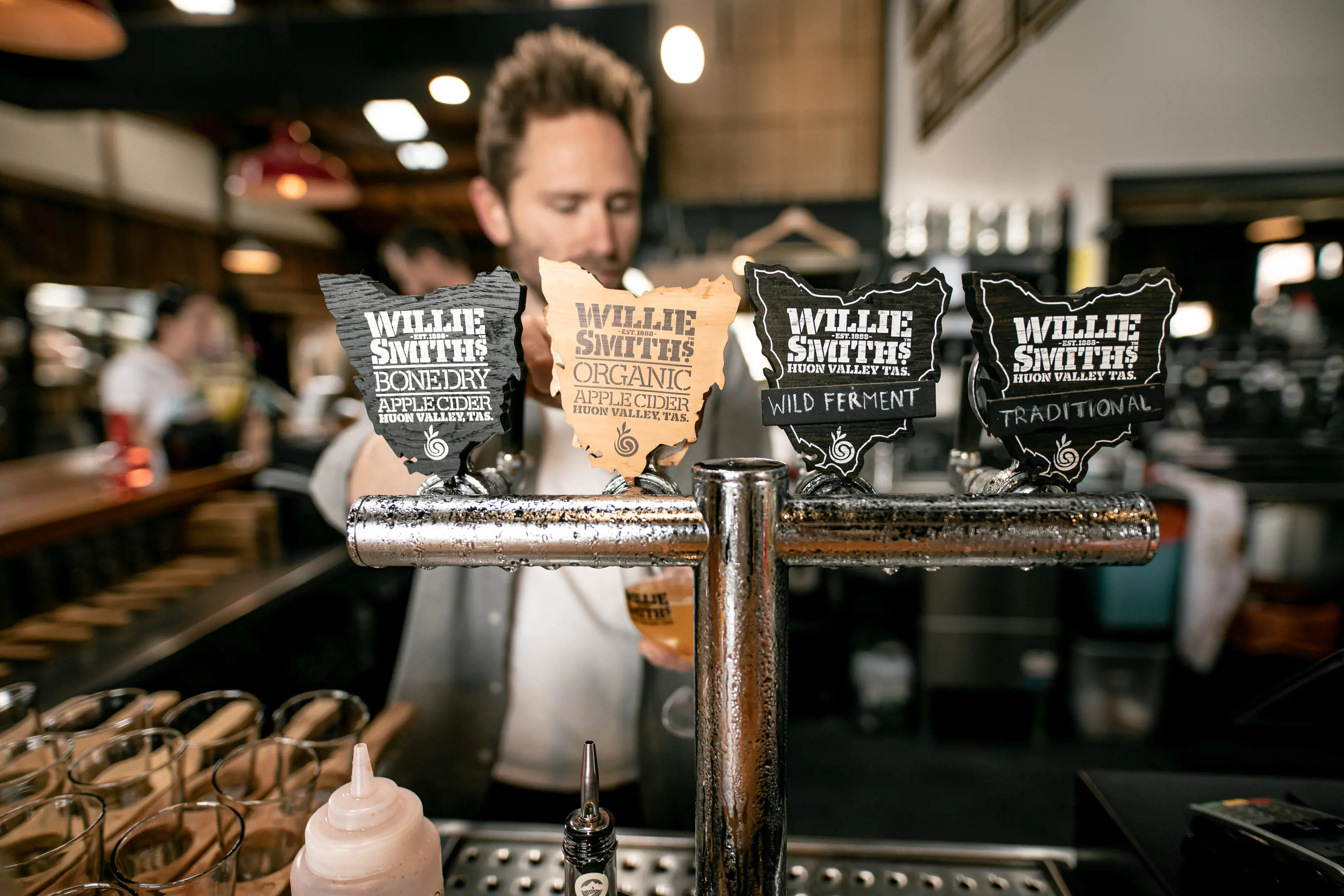 Close up image of four different flavours of cider on tap at Willie Smith's Apple Shed.