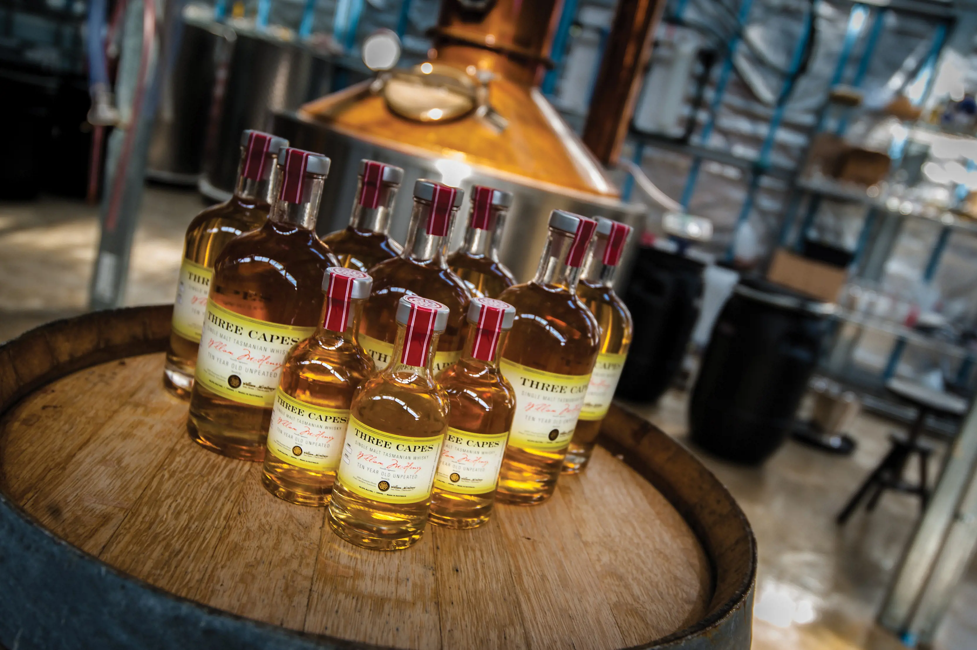 Bottles of whisky placed on a barrel within the McHenry Distillery.