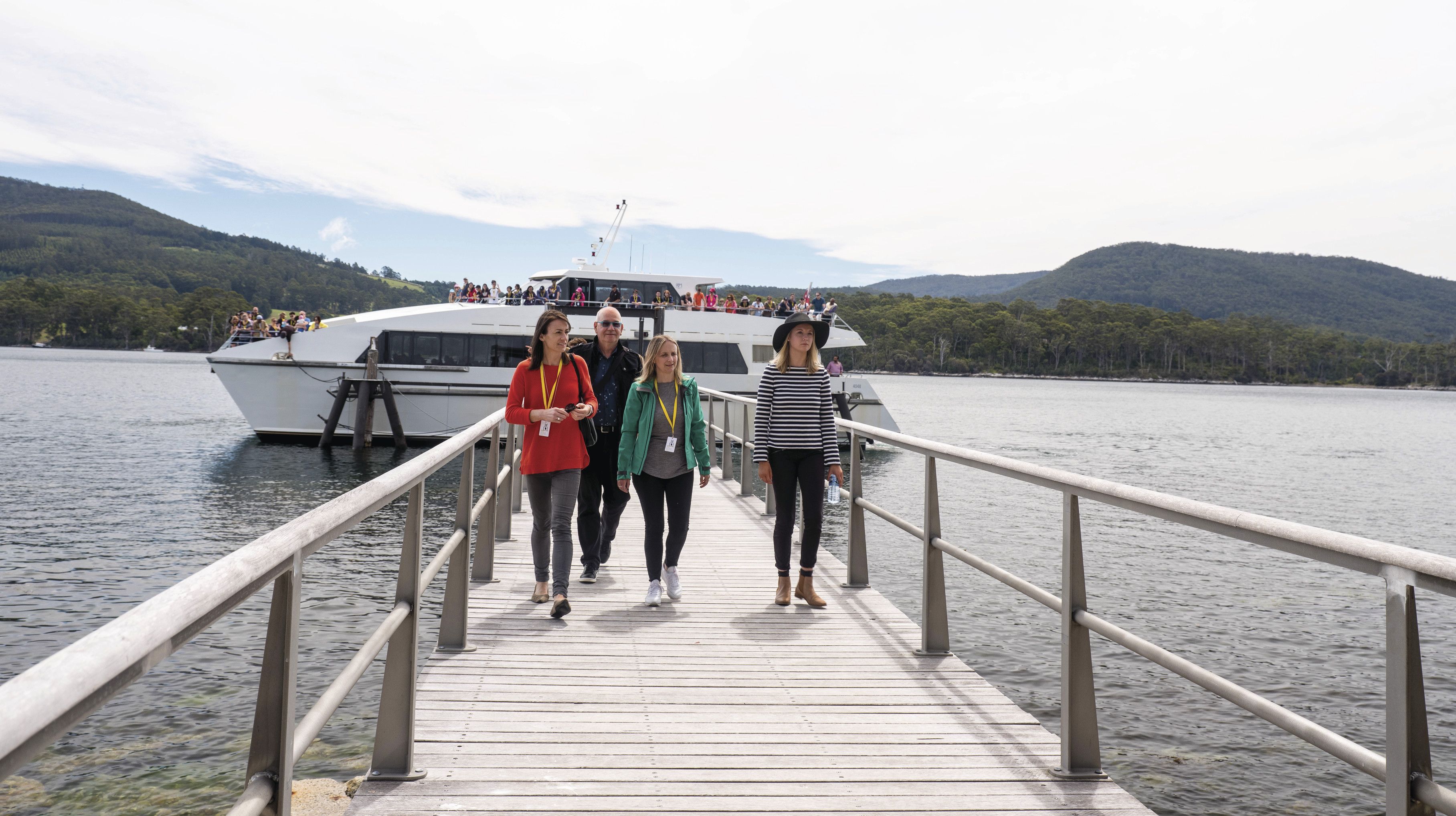 Tourists leaving the boat to walk along the bridge of the Isle of the Dead - Port Arthur Historic Site.