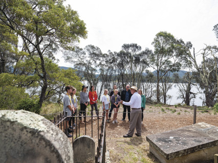 Tour guide with tourists around the graveyard of the Isle of the Dead - Port Arthur Historic Site.