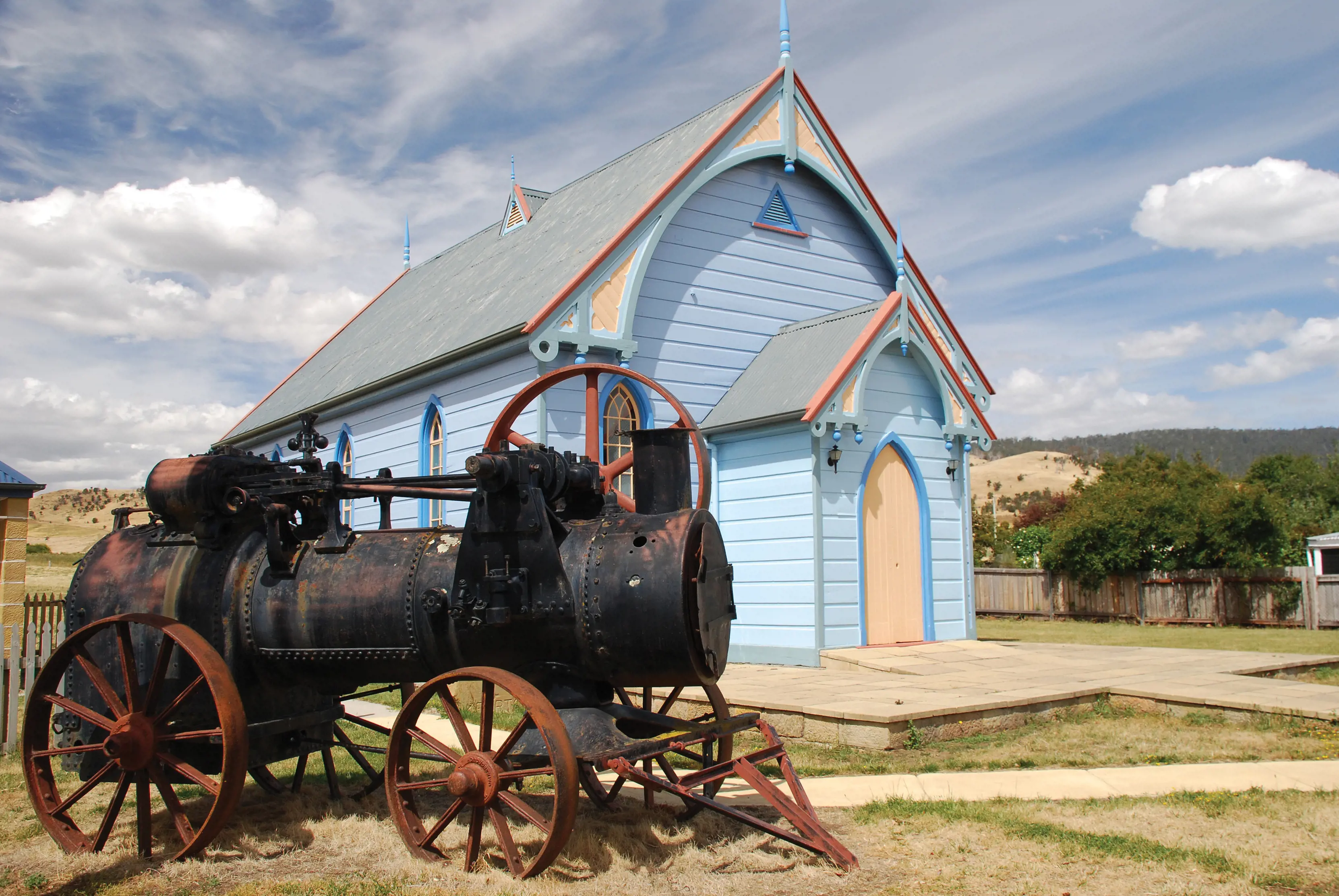 Exterior of The Blue Place, Kempton Presbyterian Church, a church painted blue. There is an old, rusted vehicle out front.