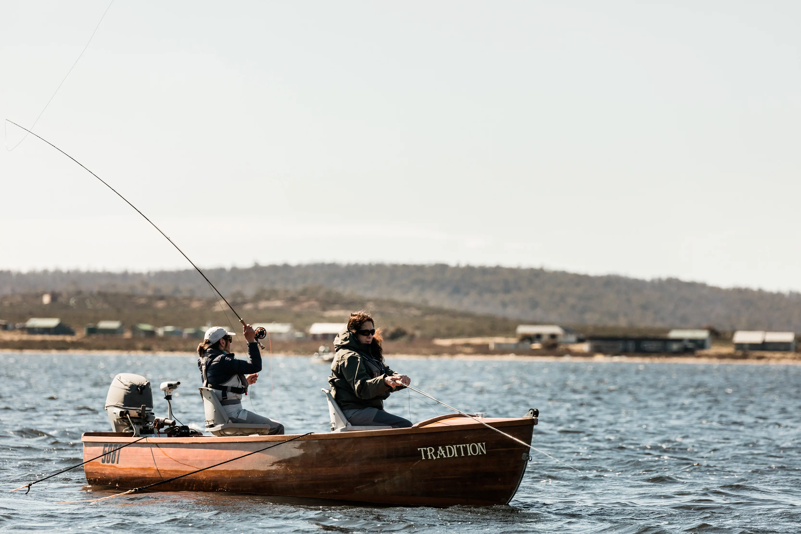 Two people enjoying fly fishing on a boat at Little Pine Lagoon.