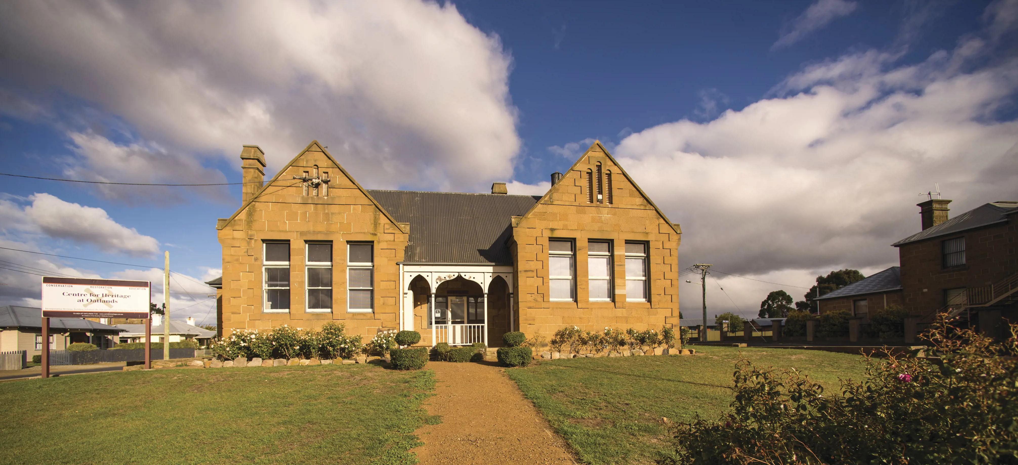 Sandstone house, positioned at the end of a long path. 