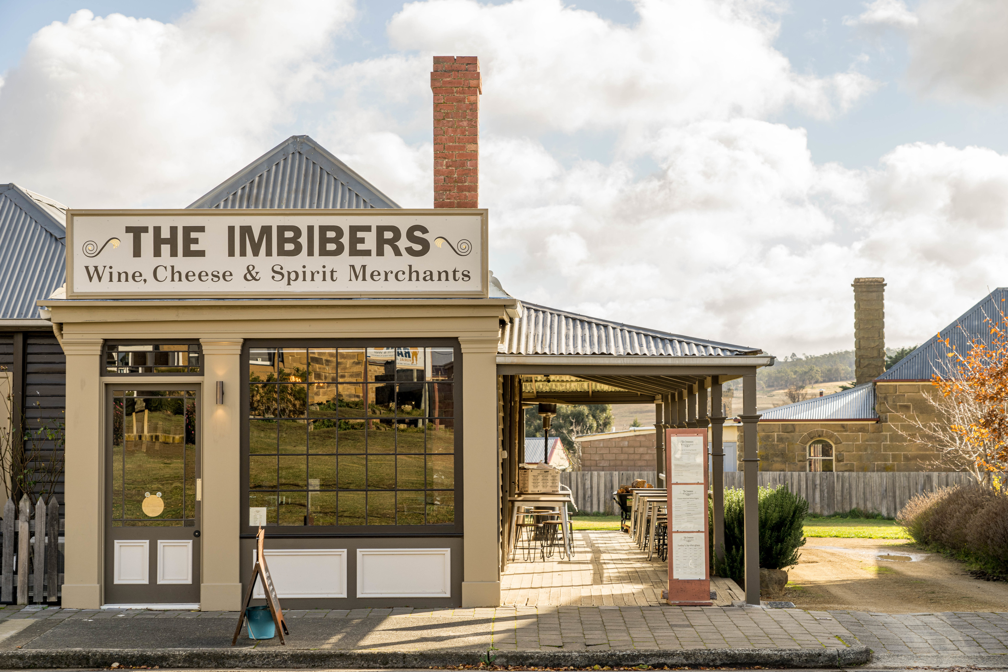 Vintage looking shop front shot with a tall brick chimney at the Imbibers