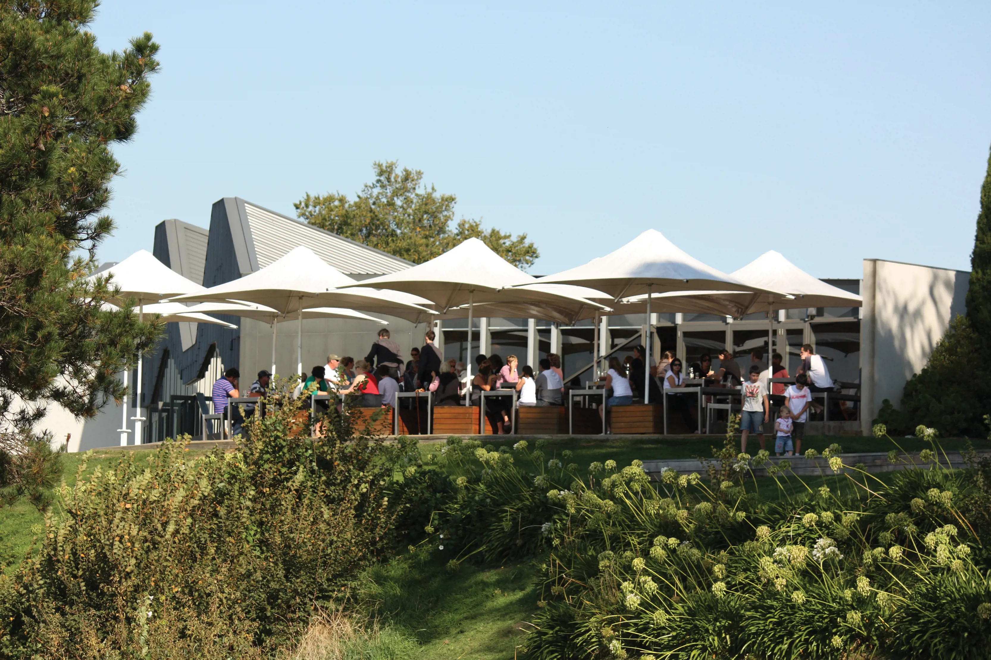 Crowds of people enjoying food sat outdoors at Stackings Restaurant, Peppermint Bay.