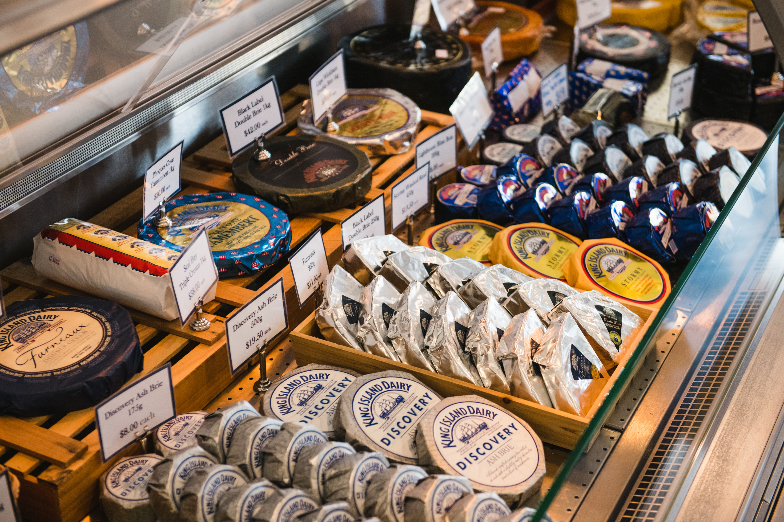 Close up image of a large variety of cheeses in the display of the King Island Dairy.