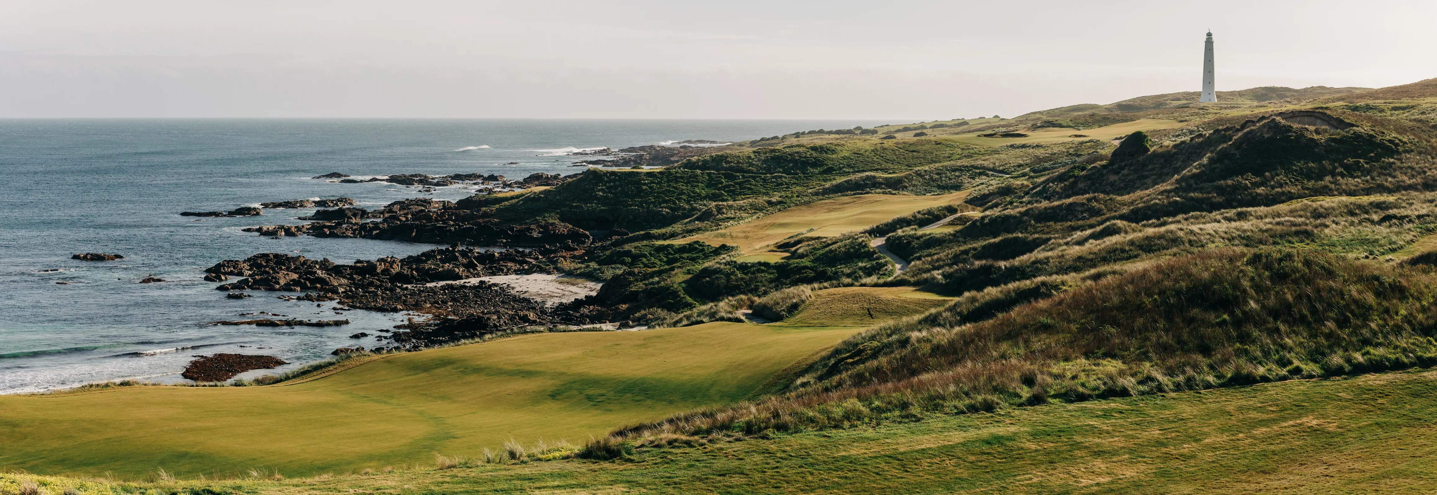 Lighthouse on Cape Wickham golf Course. Grassy hill coming off the ocean side