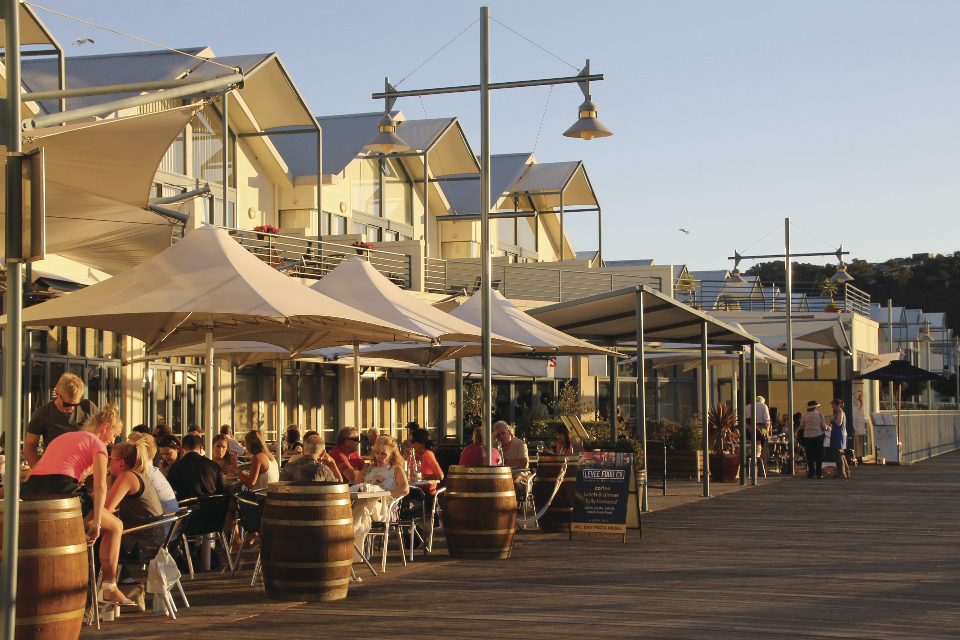 Crowds enjoy food and drink in the sun at the cafes and restaurants along Launceston Seaport boardwalk.