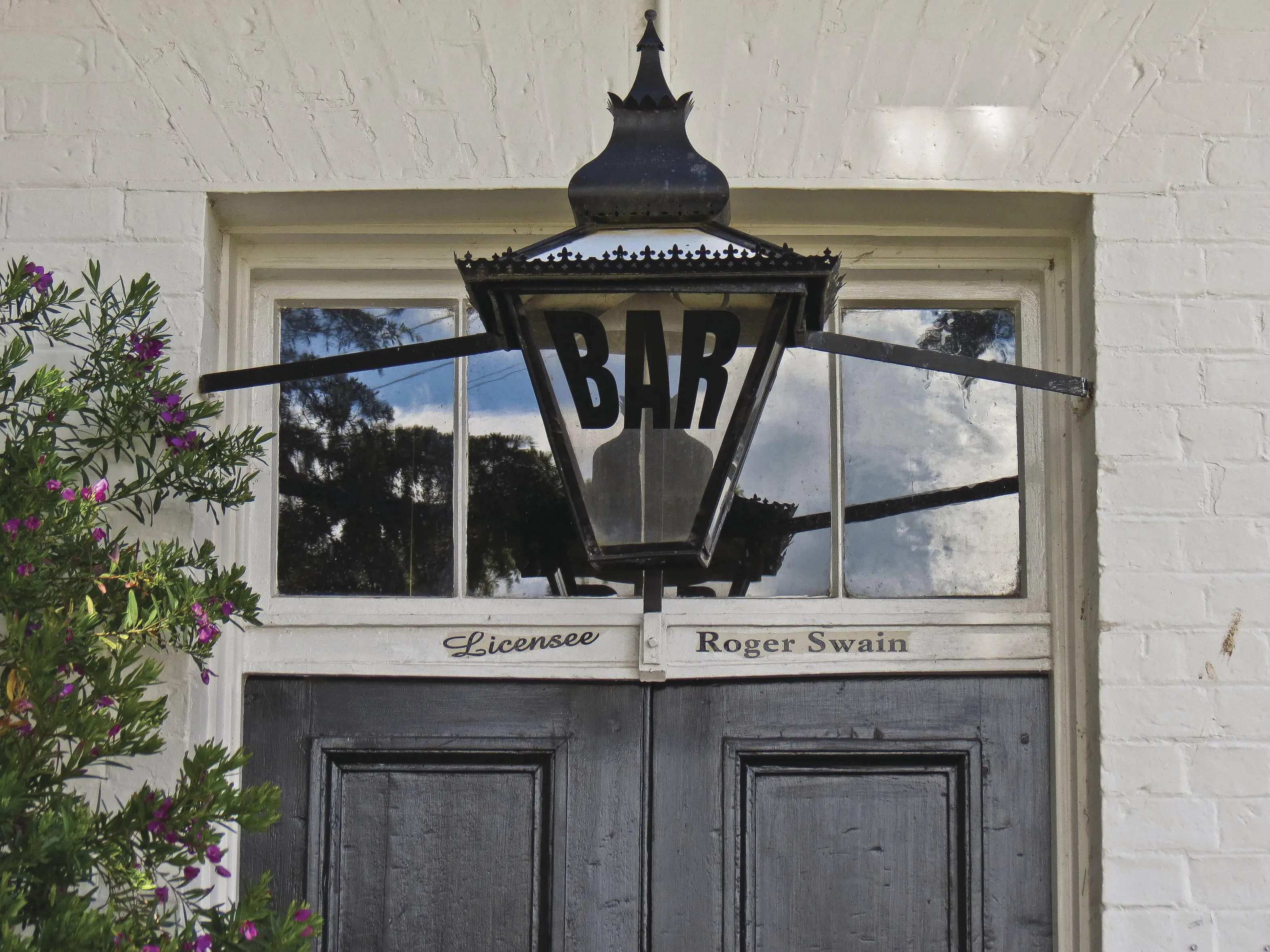 Bar is written on a lamp outside The Fitzpatrick's Inn. The following writing is also on the door 'licensee - Roger Swain'.