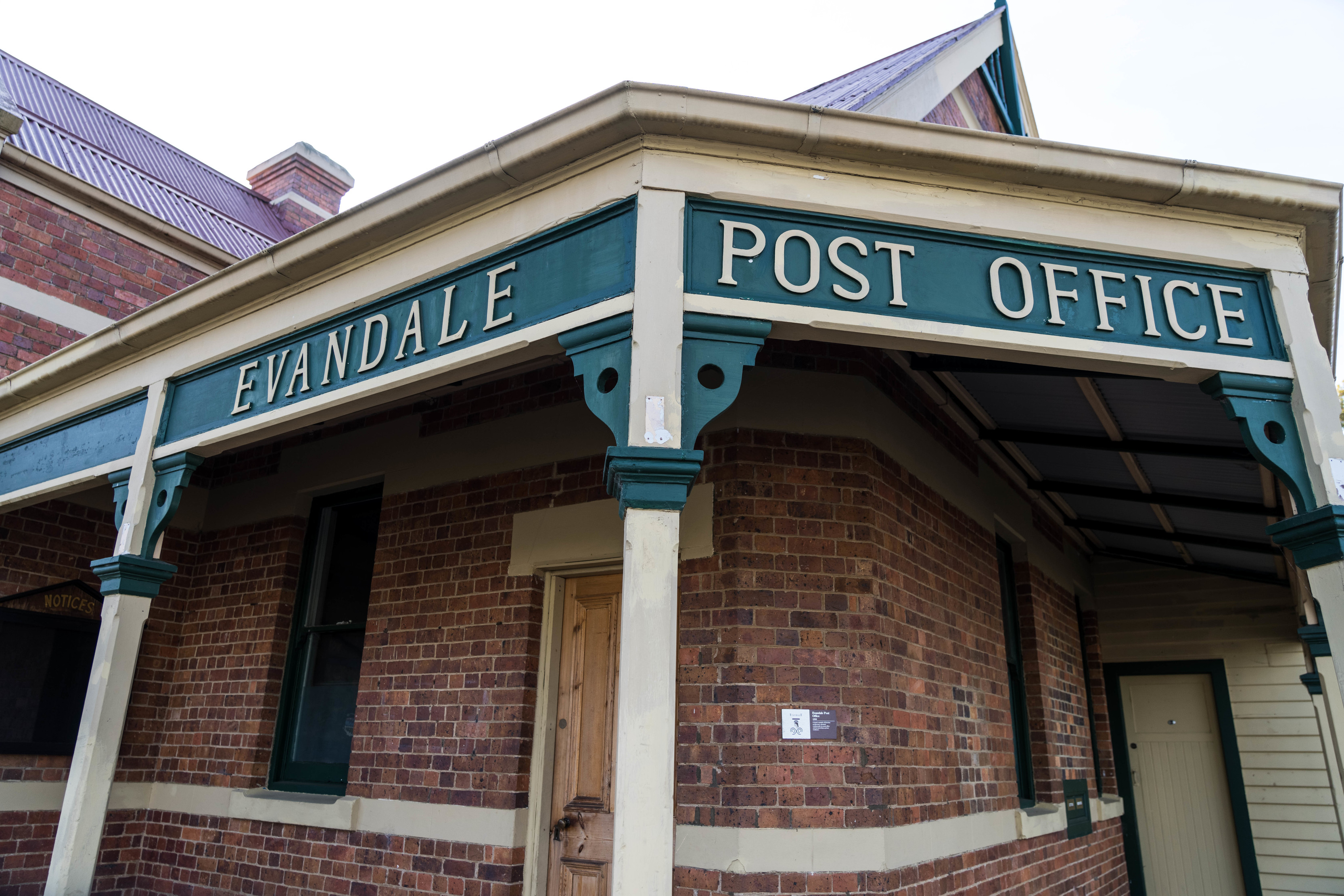Old Evandale Post Office sign on blue painted wood.
