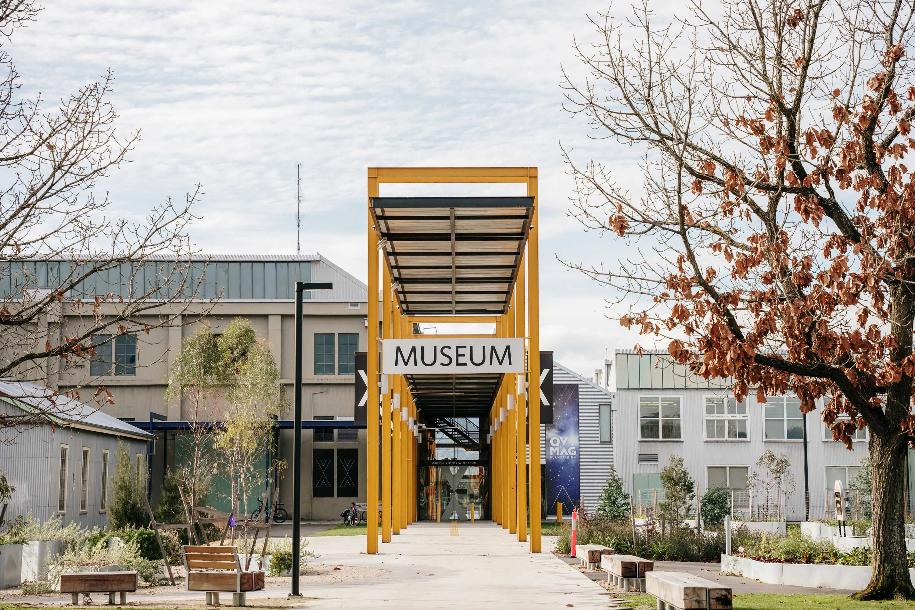 The yellow arches of the QVMAG entrance at Inveresk, bordered with seating and an expansive garden.