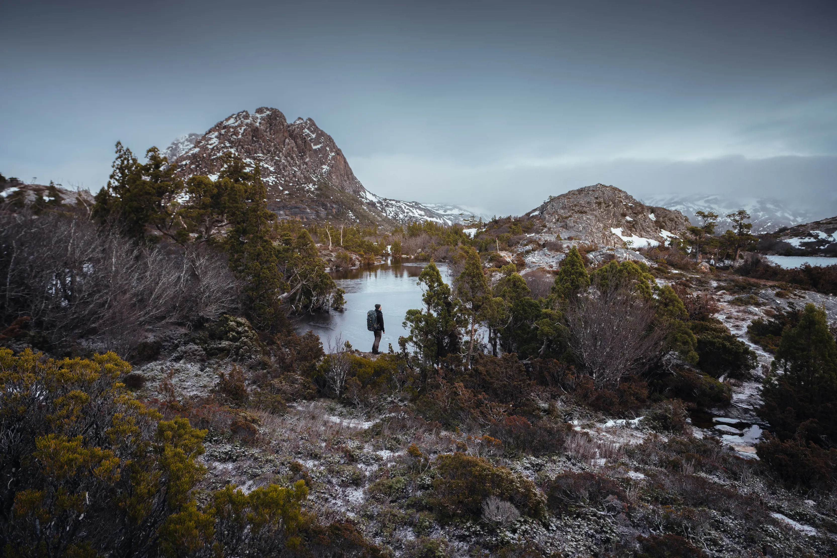 Dramatic and moody image of hiker taking in the incredible view of Twisted Lakes and its surroundings.