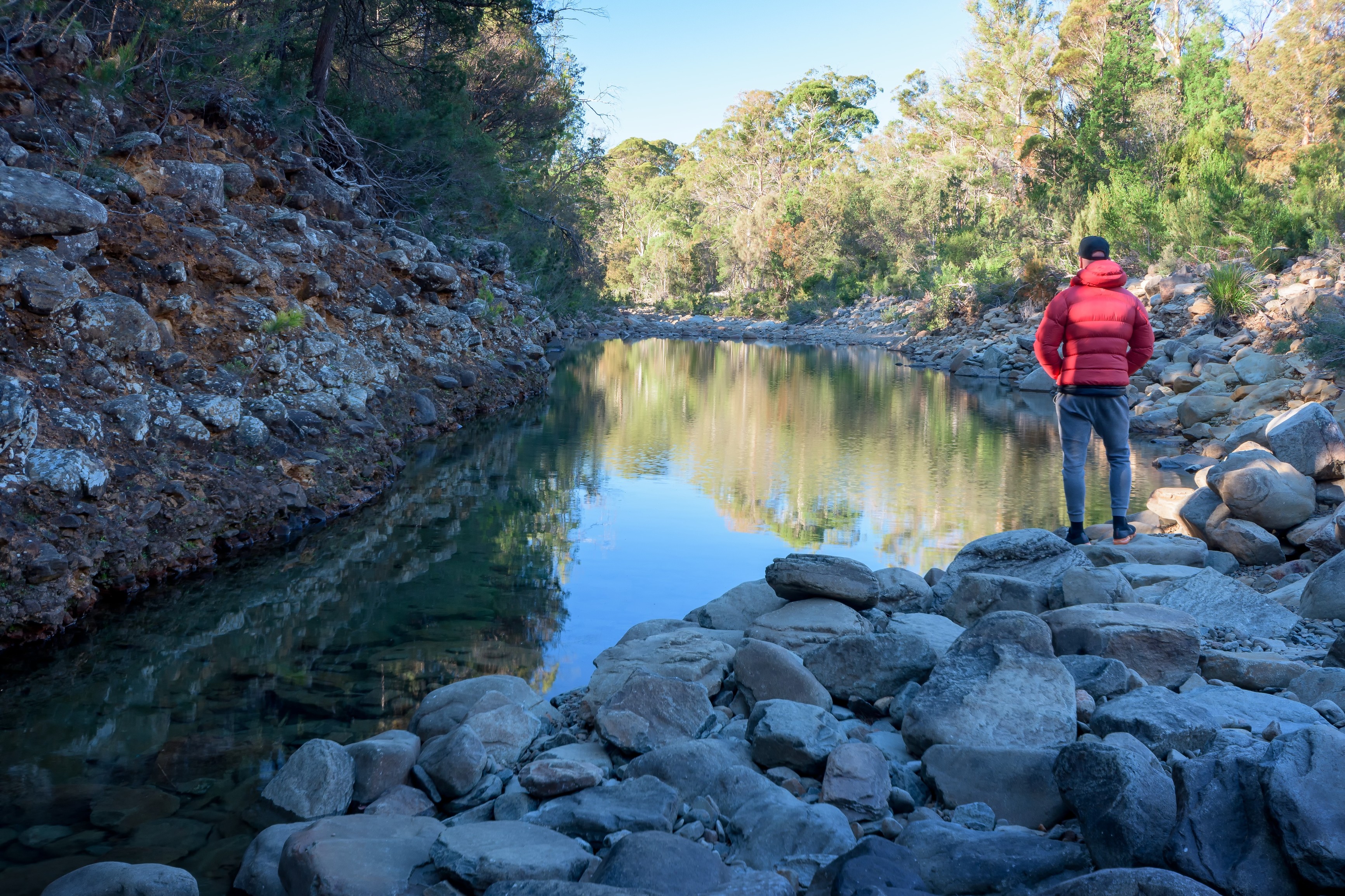 A man stops and looks over the water at Apsley Gorge