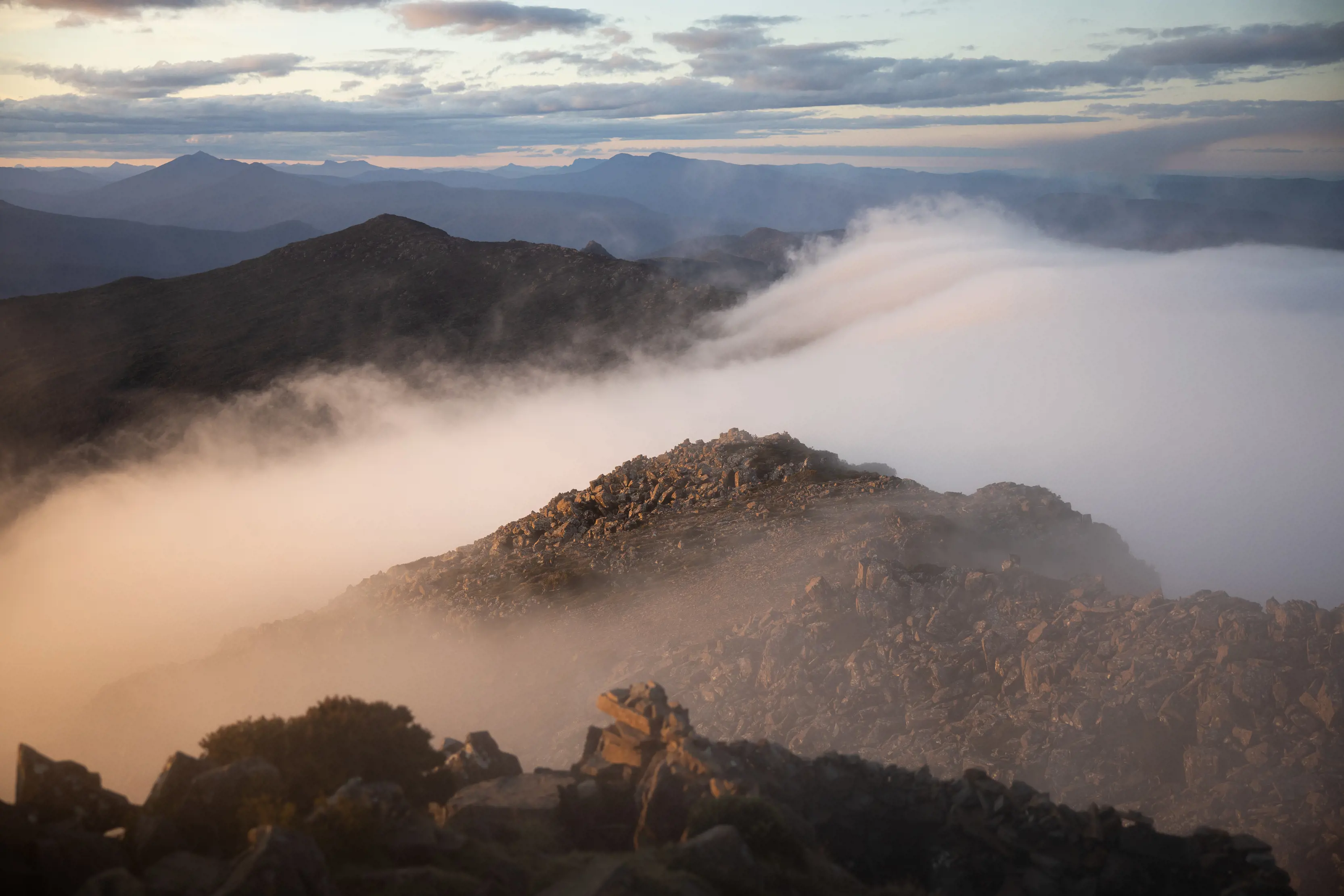 Incredible image of clouds rolling off the mountains during a vibrant sunrise at the Hartz Mountains National Park.