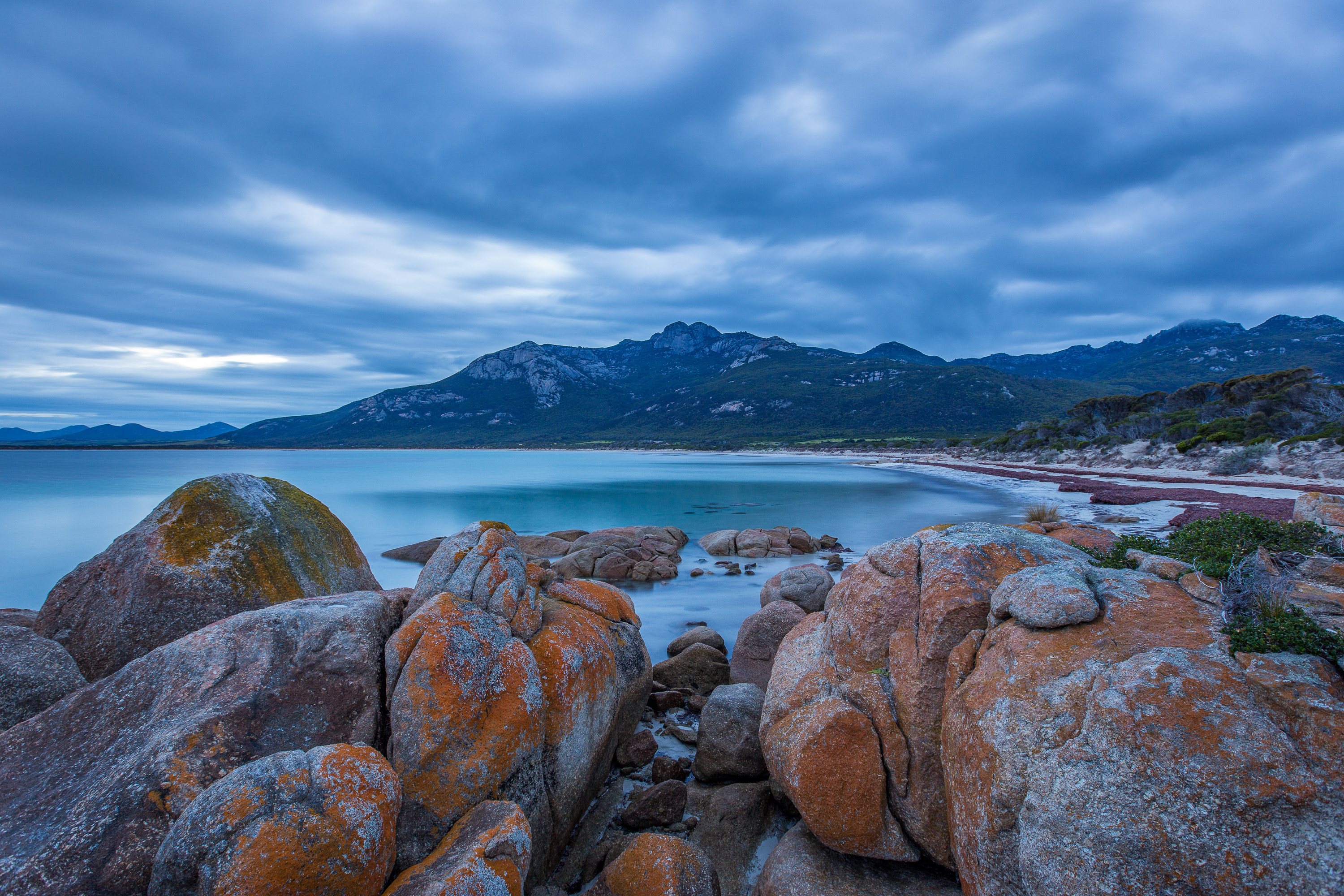 Breathtaking image of Fotheringate Bay, Flinders Island. With large vibrant rocks and a stunning shoreline running down, during sunset.