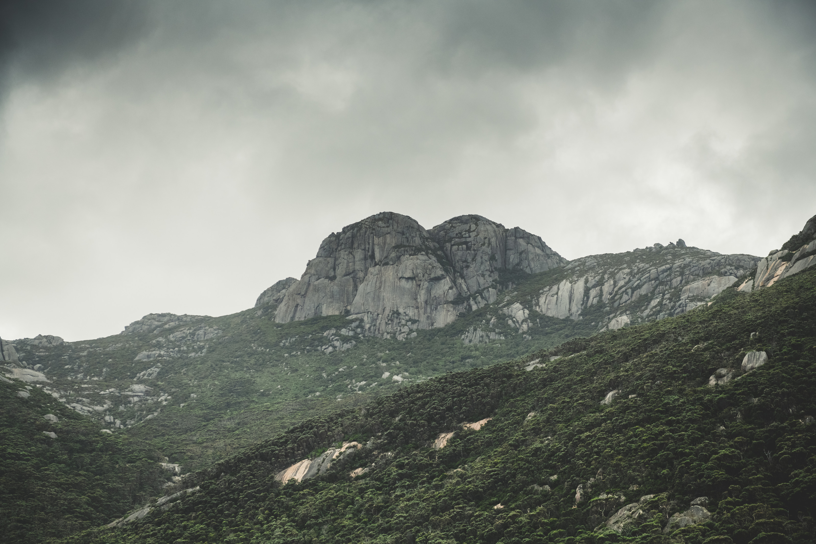 A dramatic and moody image of Strzelecki Peaks, Strzelecki National Park. Surrounded by bushland and clouds.