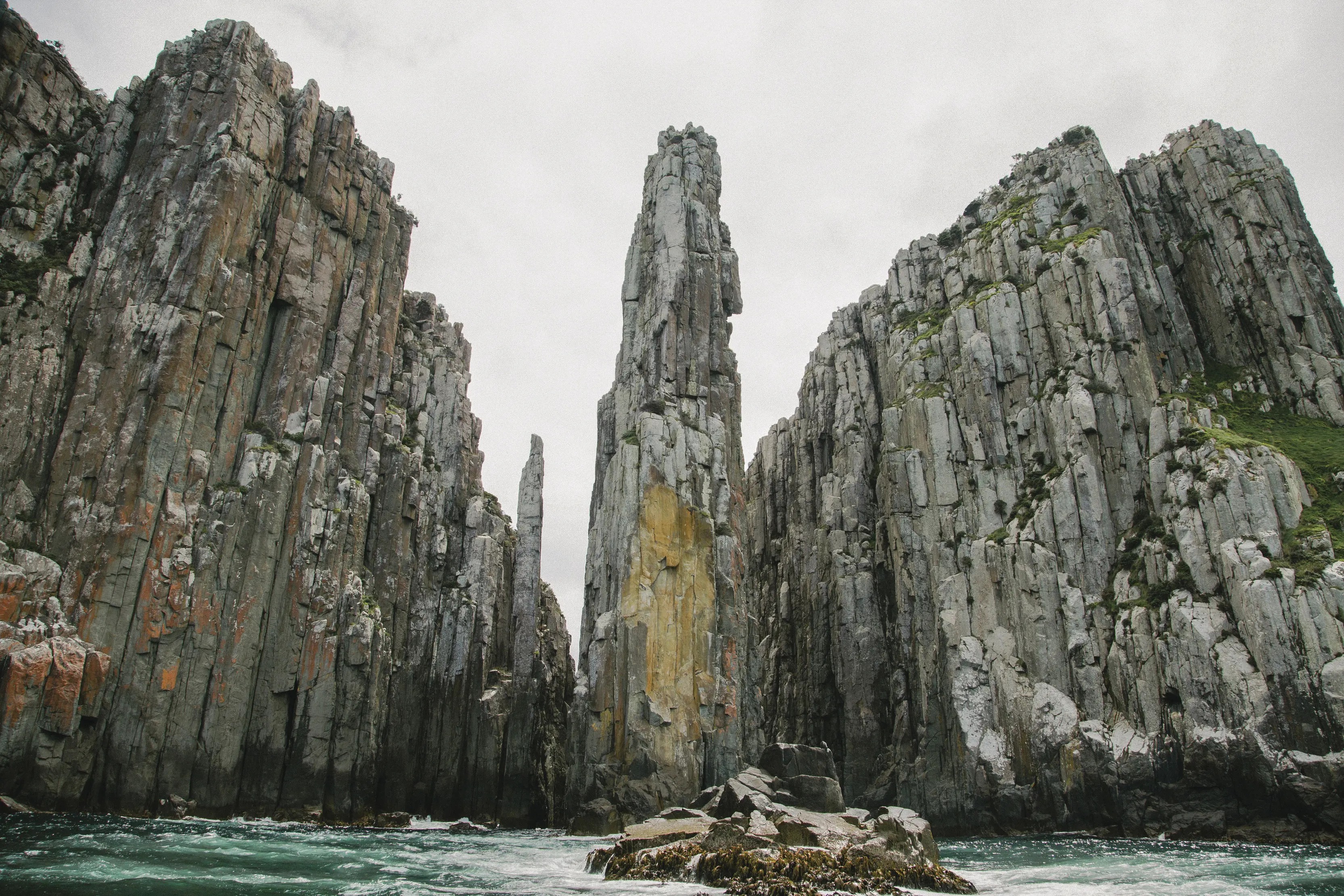 Breathtaking image of the Candlestick, taken from the ocean. Surrounded by tall rock walls and striking blue ocean.