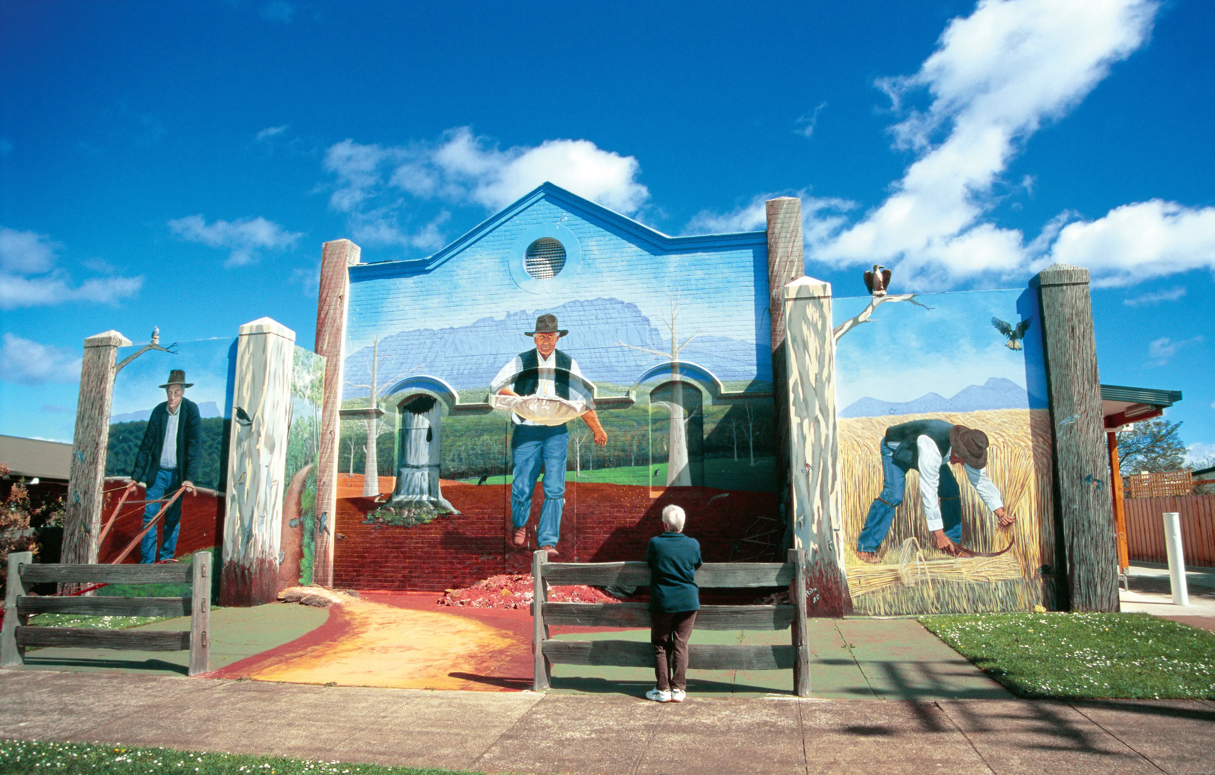 Image of the incredible and vibrant Sheffield Murals with a person admiring it. Bursting with colours.