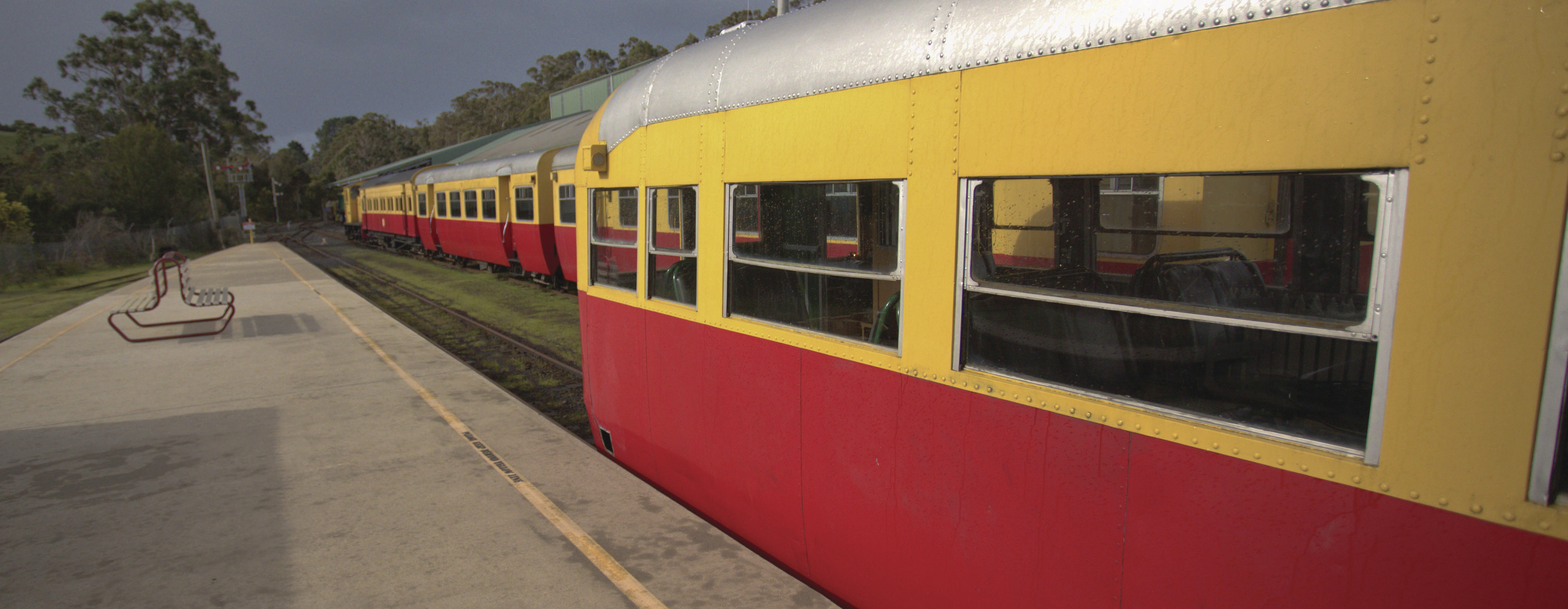 Image of a vintage red and yellow carriage at a platform at the Don River Railway and museum in Don, a suburb of Devonport.