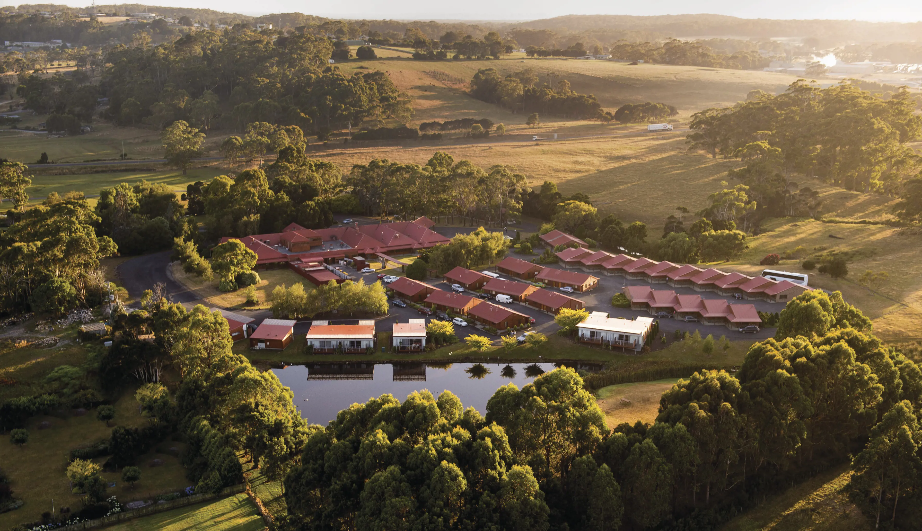 Stunning aerial image of the Tall Timbers Tasmania, with the sunrise casting a warm comforting tone over the hotel.