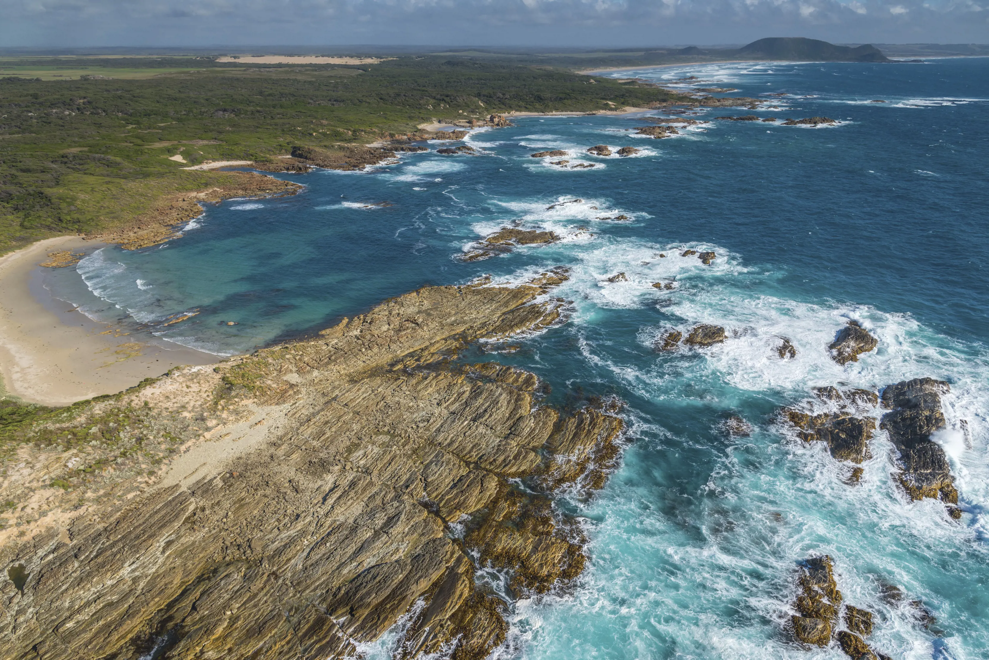 Incredible aerial image over Temdudheker / Woolnorth Point. The rugged coastline meets the striking blue water on clear sunny day. 