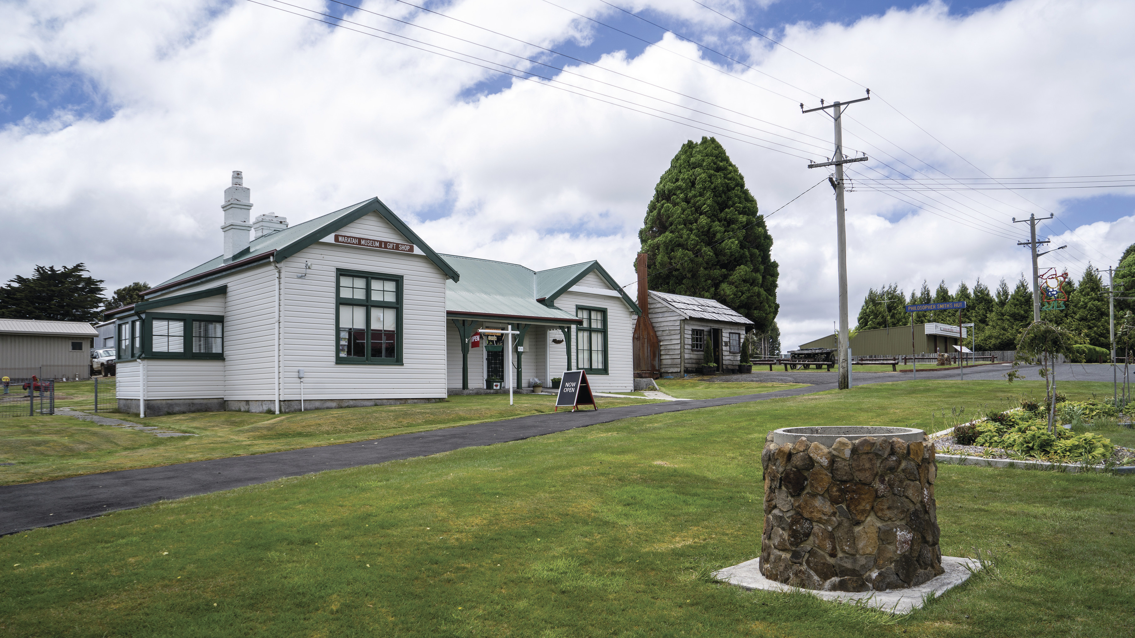 Image of the Waratah Courthouse Museum. A replica of 'Philosopher' Smith's Hut sits next to the Museum.