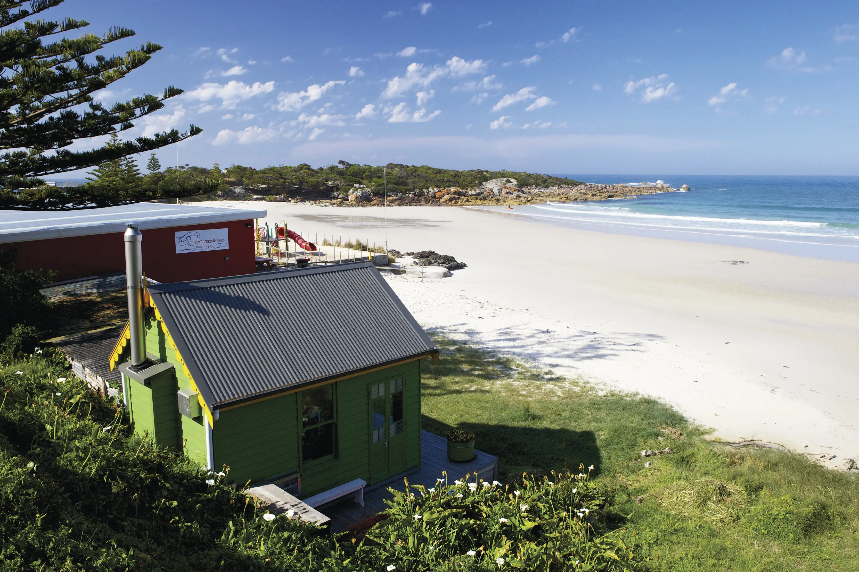 Image of Boat Harbour, viewing from the coastline, out to sea. A green house is in the foreground of the image.