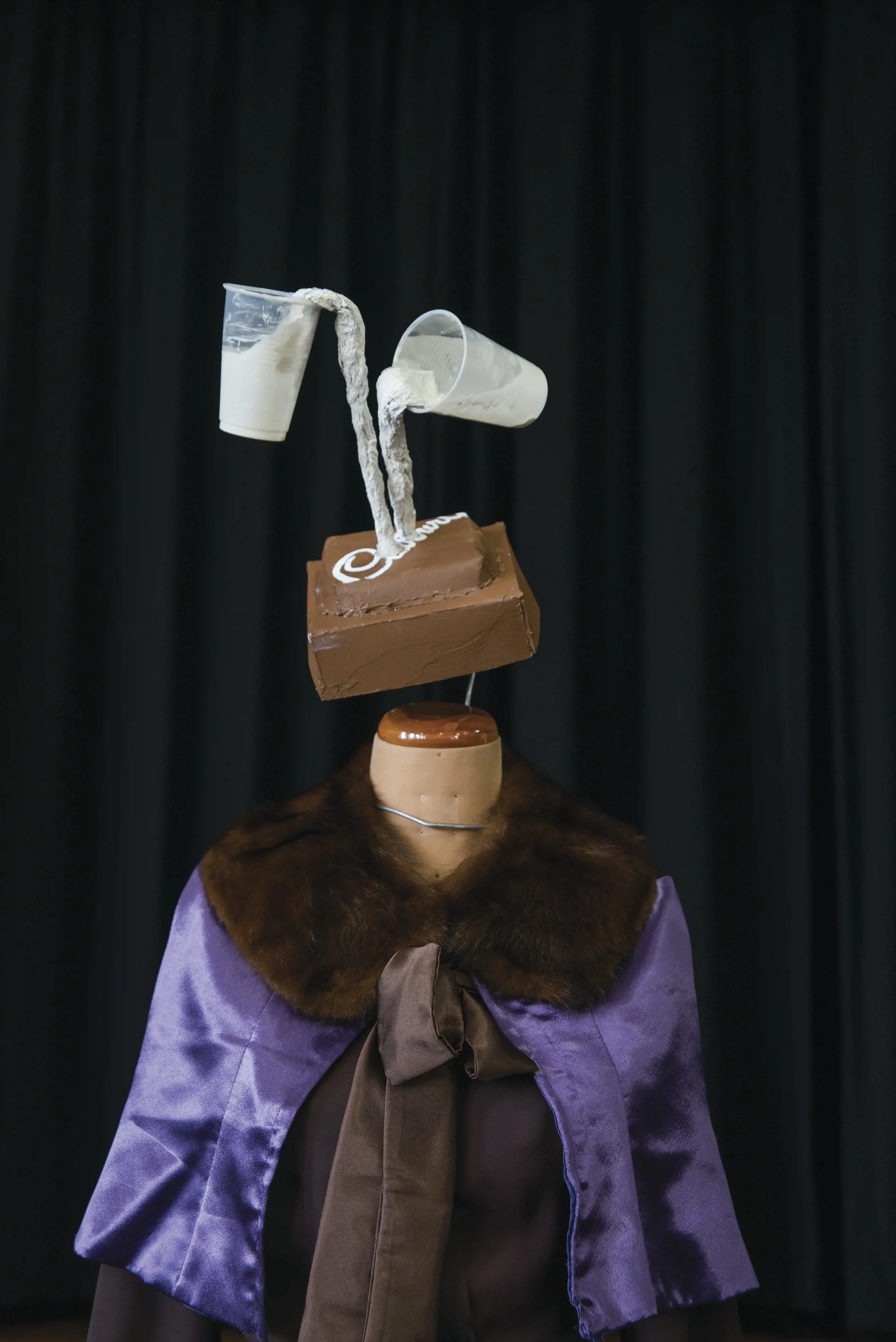 An abstract statue depicting Cadbury Chocolate block as a head with two glasses of milk poured onto it, accompanied by a mannequin body. For Chocolate Winterfest.