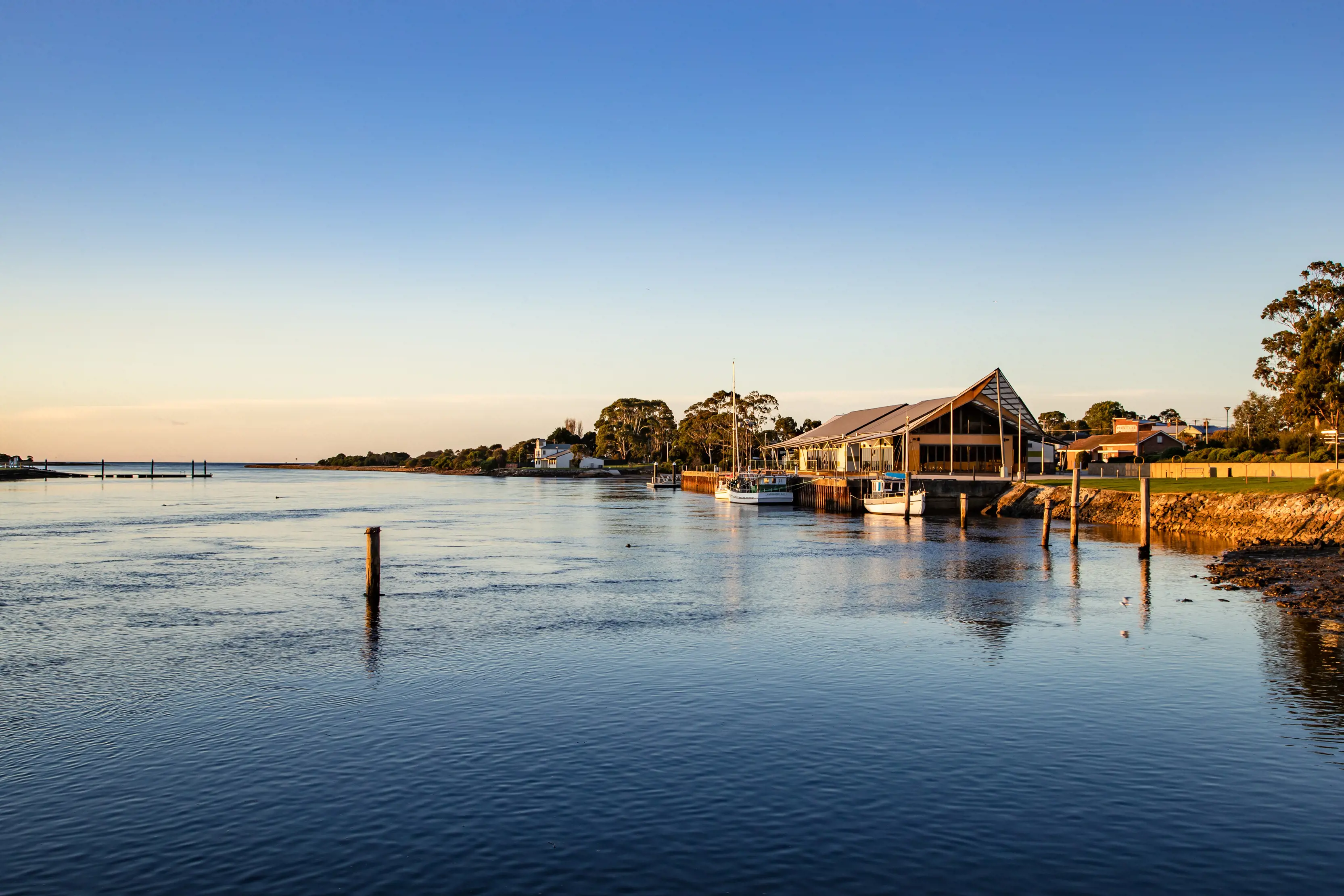 Spectacular image of the Leven River taken on sunrise. Small boats surround a small dock in the river.