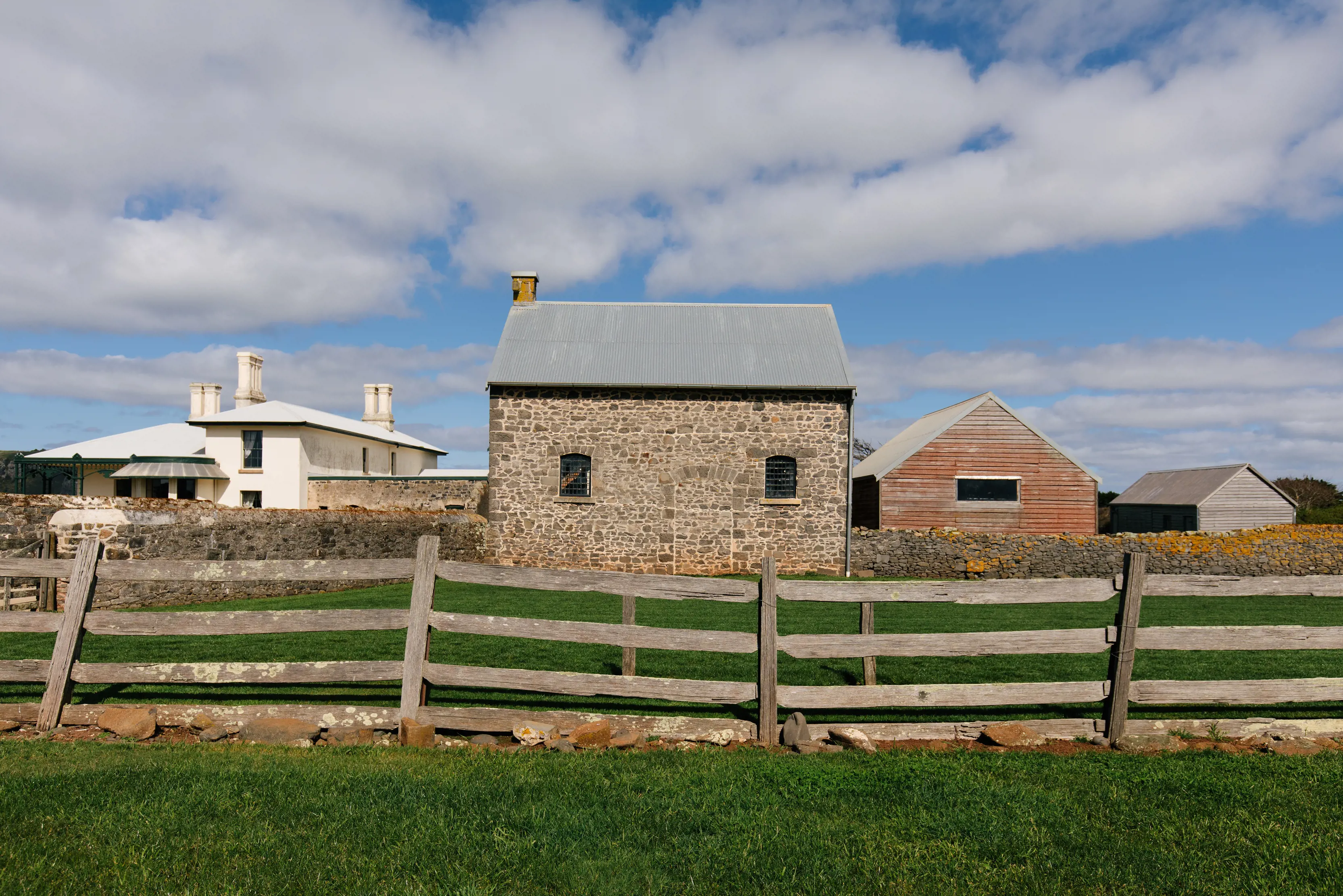 Image of the Highfield Historic Site behind a wooden fence lush, green grass.